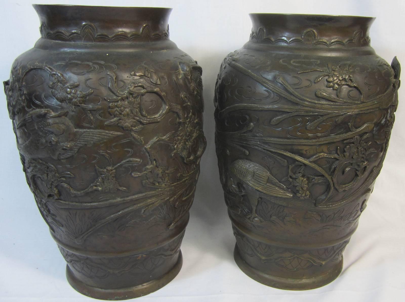 Pair of Japanese Meiji period (1868-1912) bronze urns (34cm high) on wooden bases, 
foundry mark on base. 
46 cm total height x 22 cm diameter measures.
Note minor damage to one base.