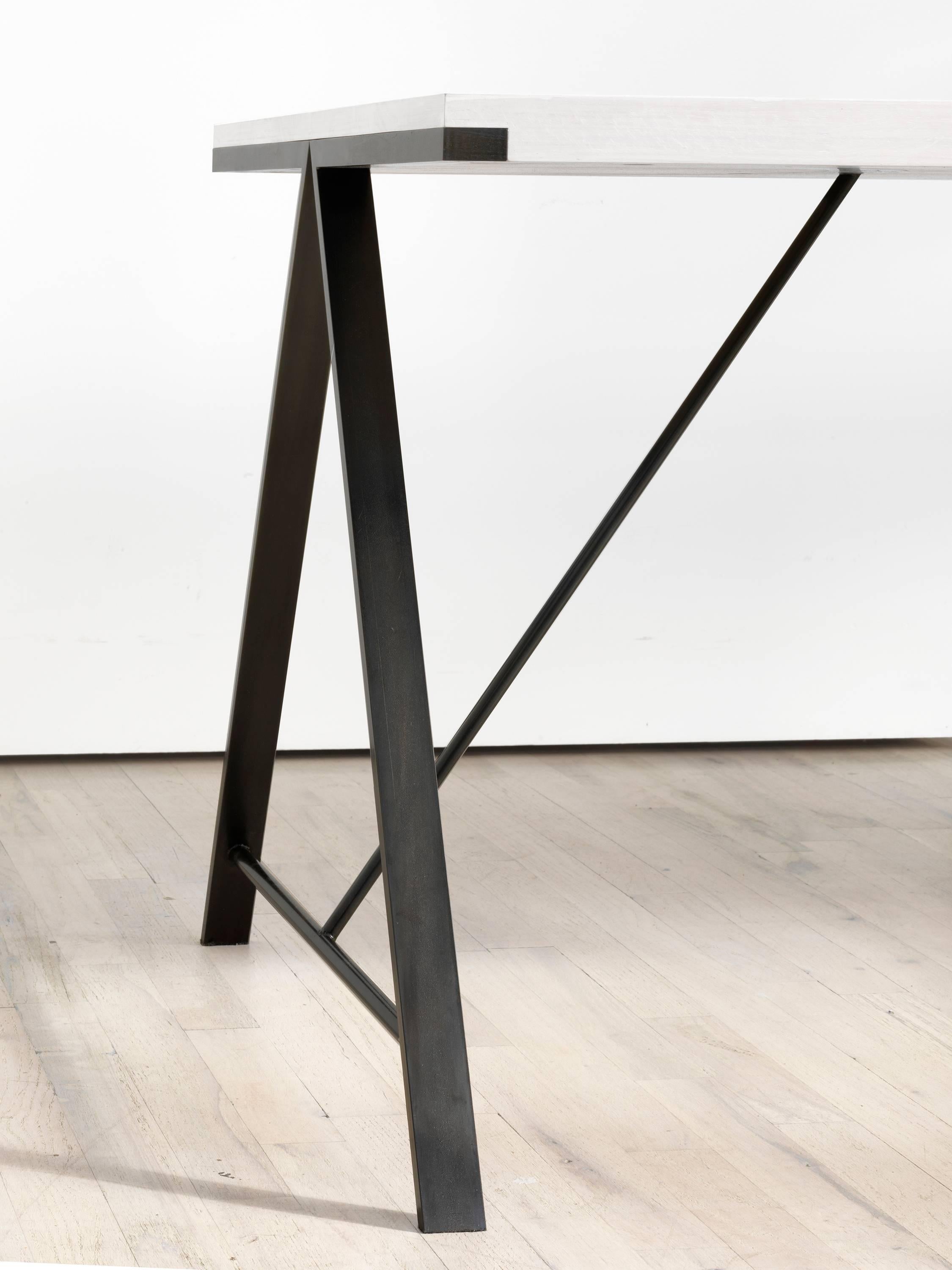 Die klaren Linien und die einfache Form des A-Table vermitteln ein Gefühl von Leichtigkeit und Präzision. Eine kleine Fuge an den Ecken drückt die Verbindung nach oben und die darin verborgene Struktur aus.