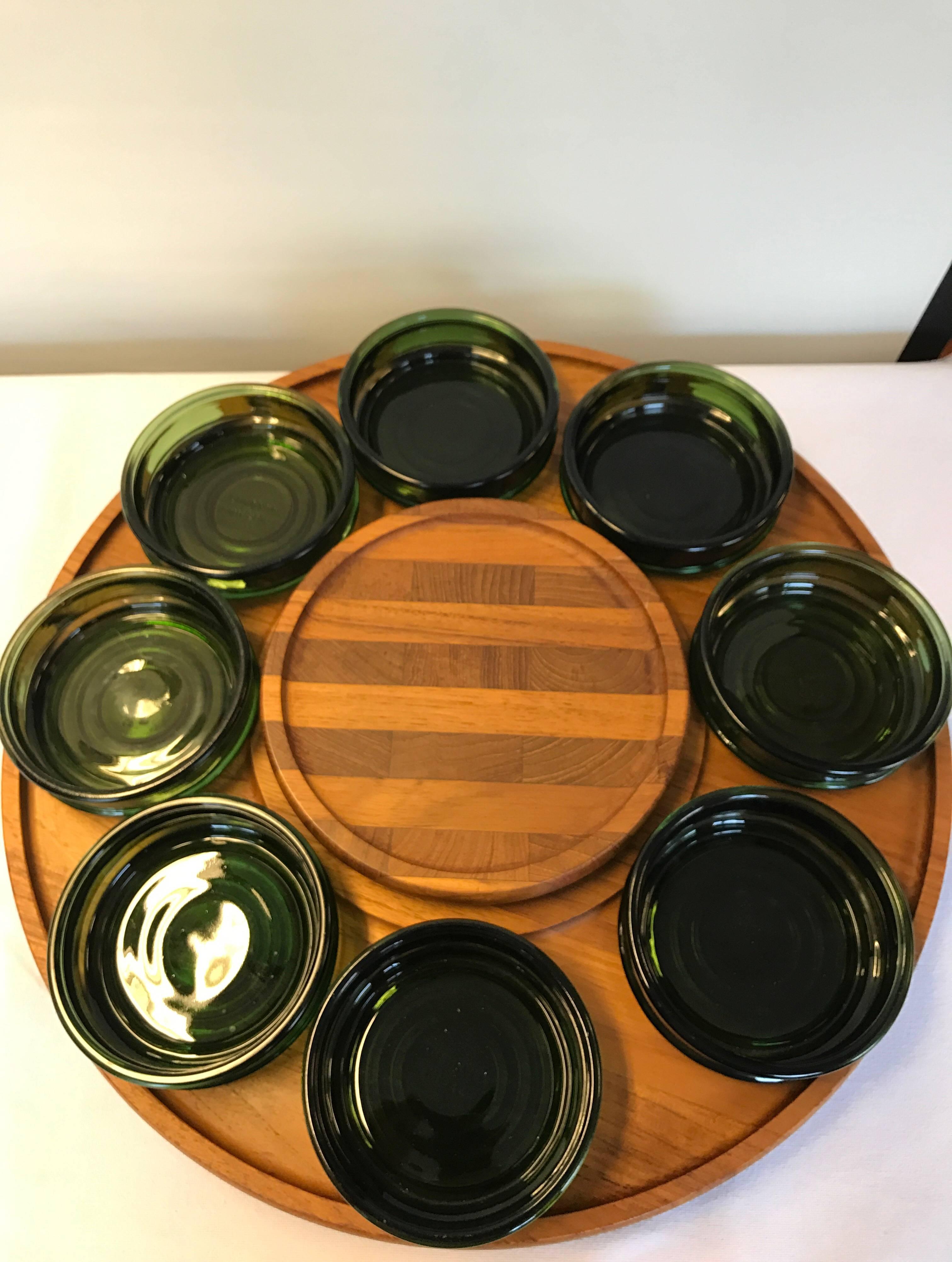 Big teak tapas tray with eight green colored glass containers, can turn around and with space for bowl in mid. Designed by Richard Nissen, 1960s, Denmark. Measures: Diameter 45 cm, height with glass containers 7 cm in very good condition.