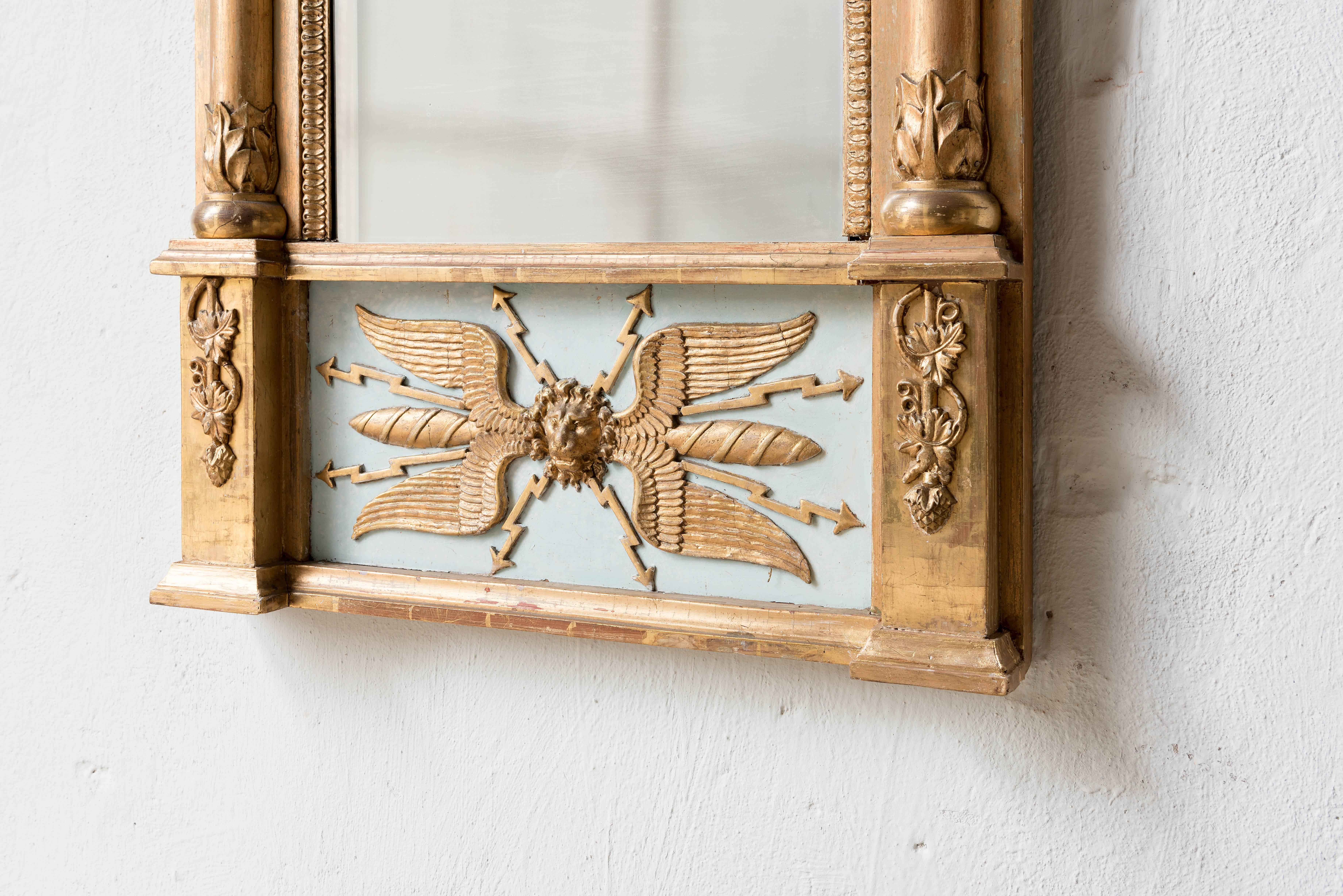 19th century Swedish Empire mirror. Original gilding and original mirror glass.
Wood carving decoration in typical Empire style.
      