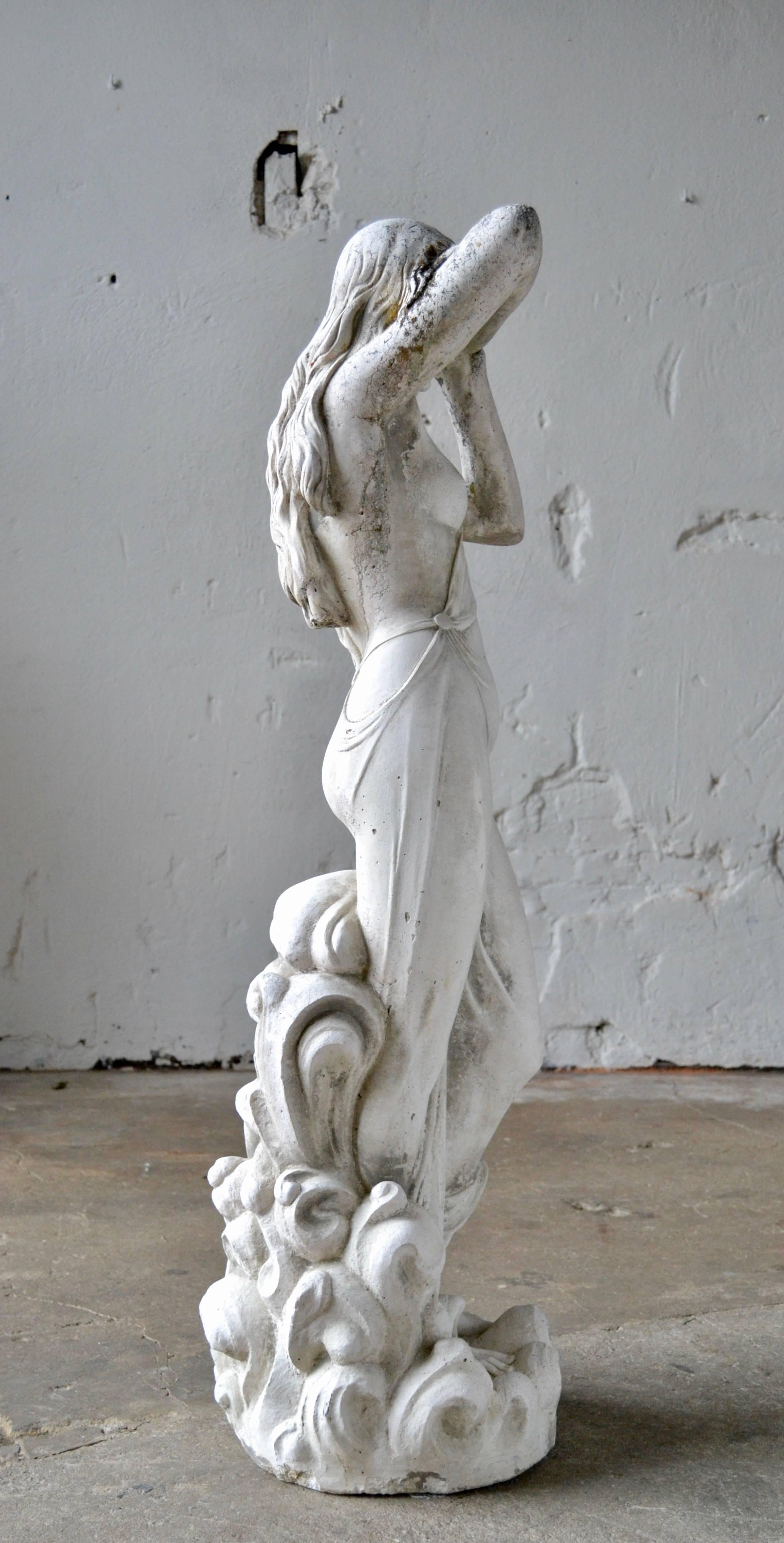 Italian marble cross garden statue, 1950s.
Beautiful Italian garden statue casted from marble cross 

This statue has wonderful proportions both in shape and appearance 
with flowers grasping her lower body.
A rare find. 
Untouched condition