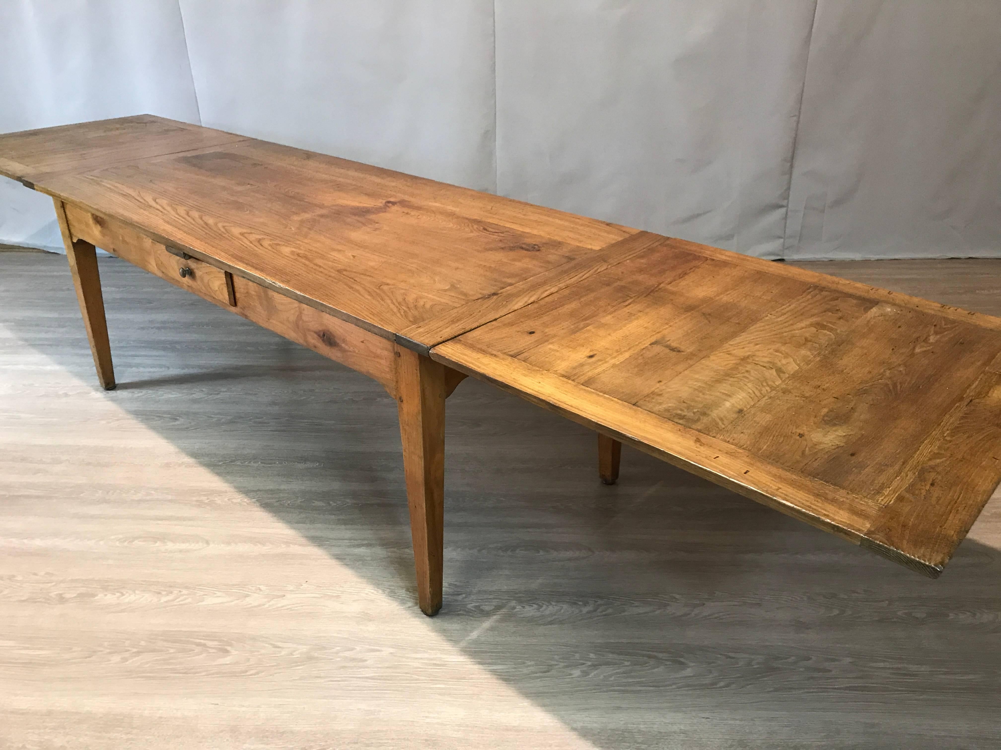 An original 19th century chestnut and cherry base draw-leaf table. This gorgeous table has a four plank chestnut cleated top with two framed chestnut leaves which sit on square tapered legs. The base is made from cherry and has a small side