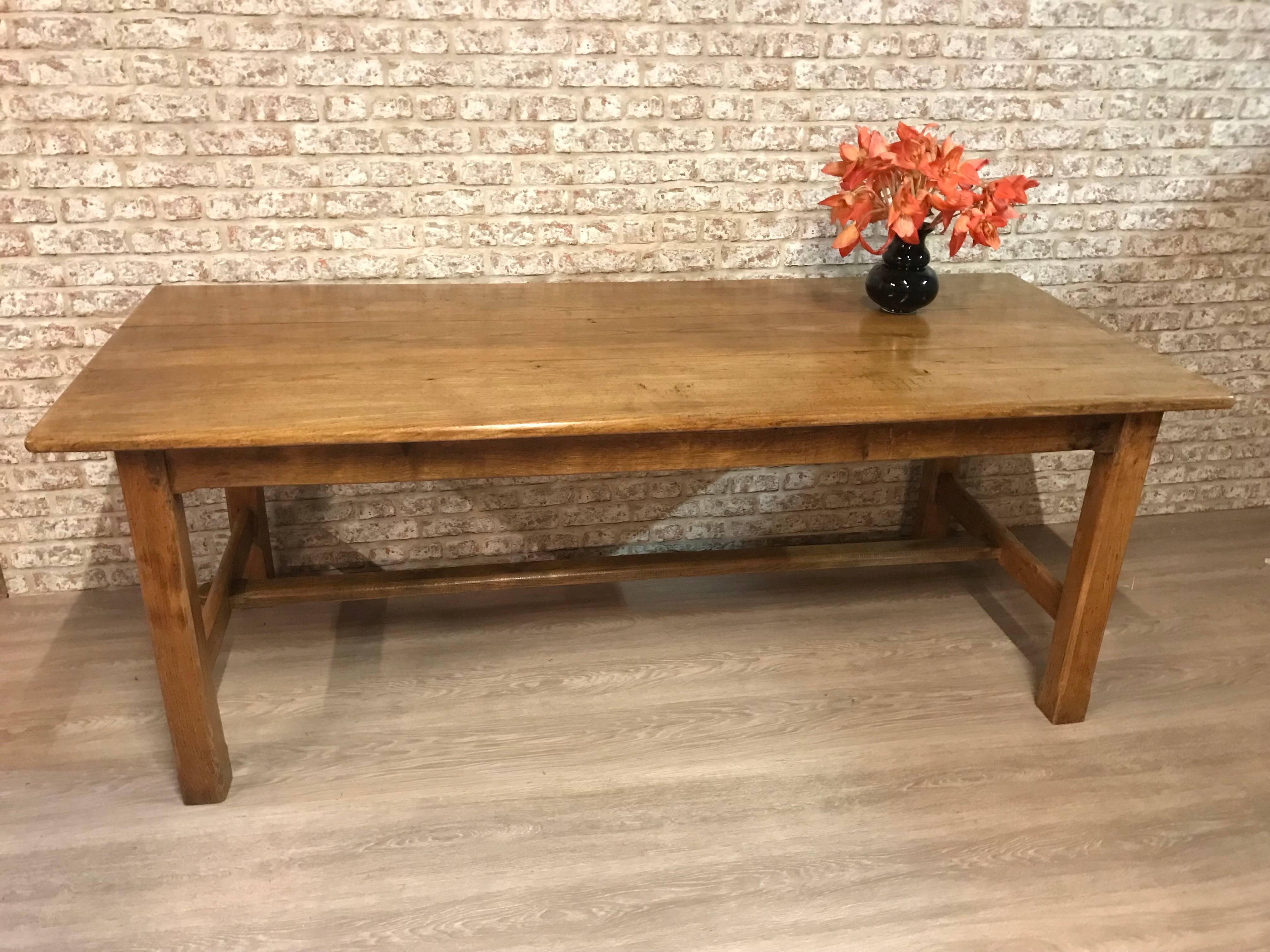 Antique pale elm farmhouse table with centre stretcher. Wonderful movement in the grain. Gorgeous table that would seat eight people comfortably. Stunning tabletop with gorgeous movement in the grain. The stretcher is supported by four square