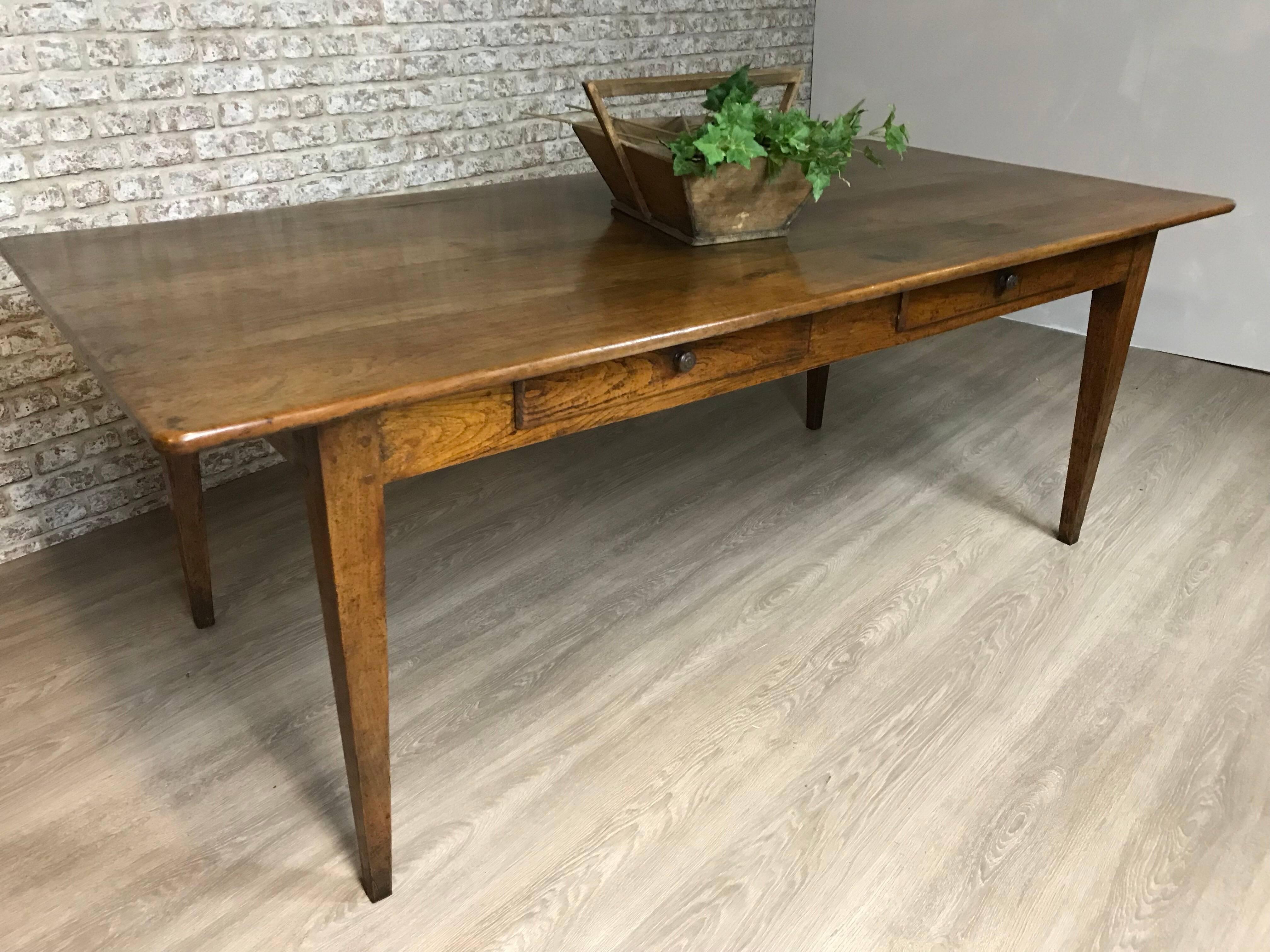 This exceptionally wide French cherry antique table with two drawers has a fabulous five-plank top. The apron sits on four tapered legs with two side drawers that finish the look of a very elegant table. The table is lovely medium brown color with