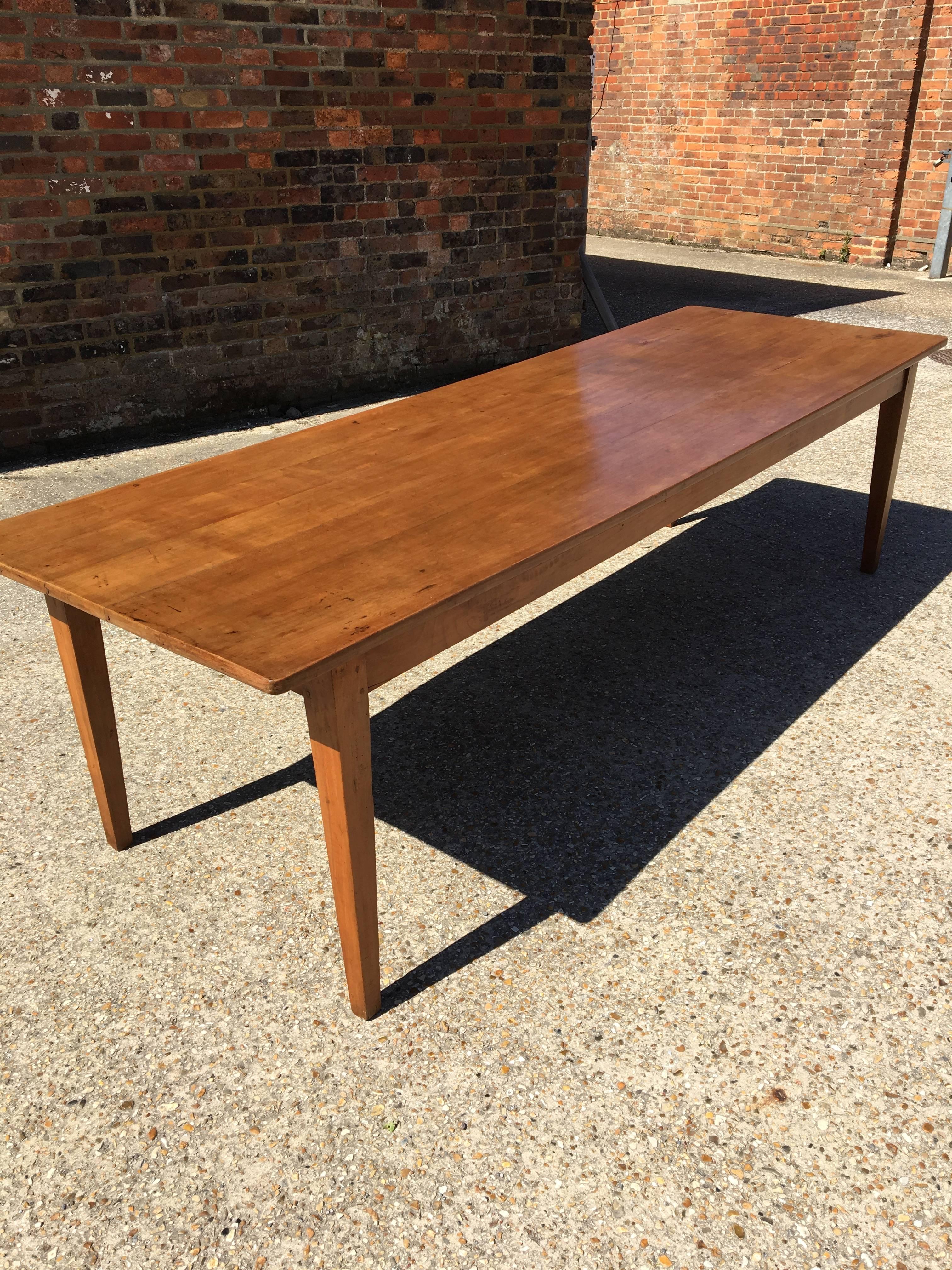 A large well proportioned late 19th century cheerywood farm house table. A warm cherry color, with a beautiful patinated top consisting of five planks, sitting on a sturdy base with very pretty tapered legs. This table standing at 9ft with a great