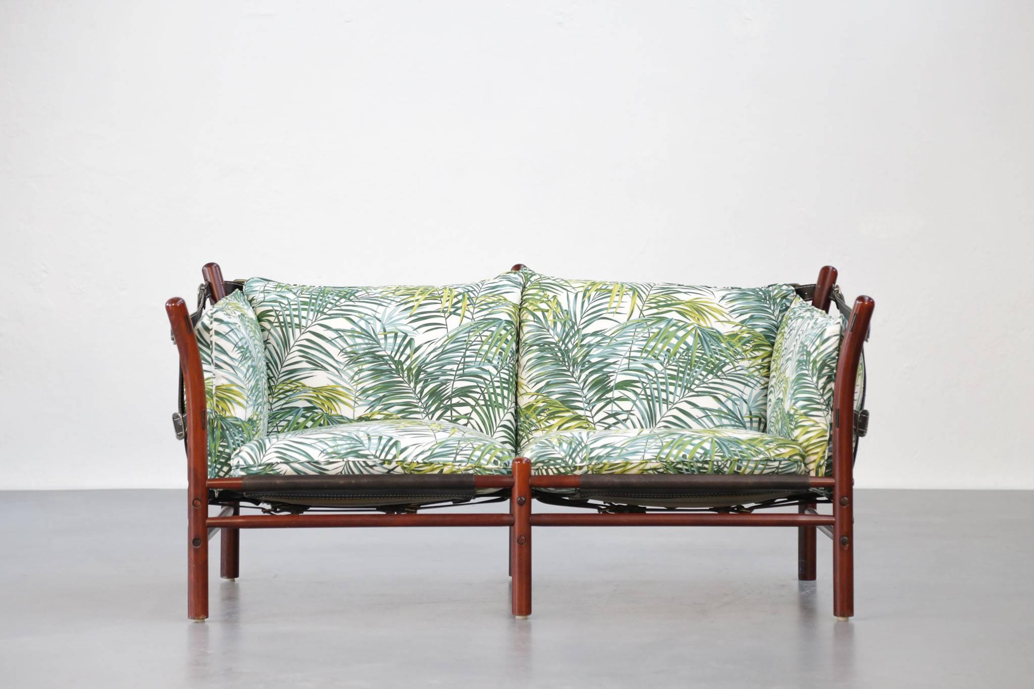 Unique sofa of the 1960s of the designer Arne Norell in massive mahogany and black leather. New Tropical cotton fabric remakes.
  