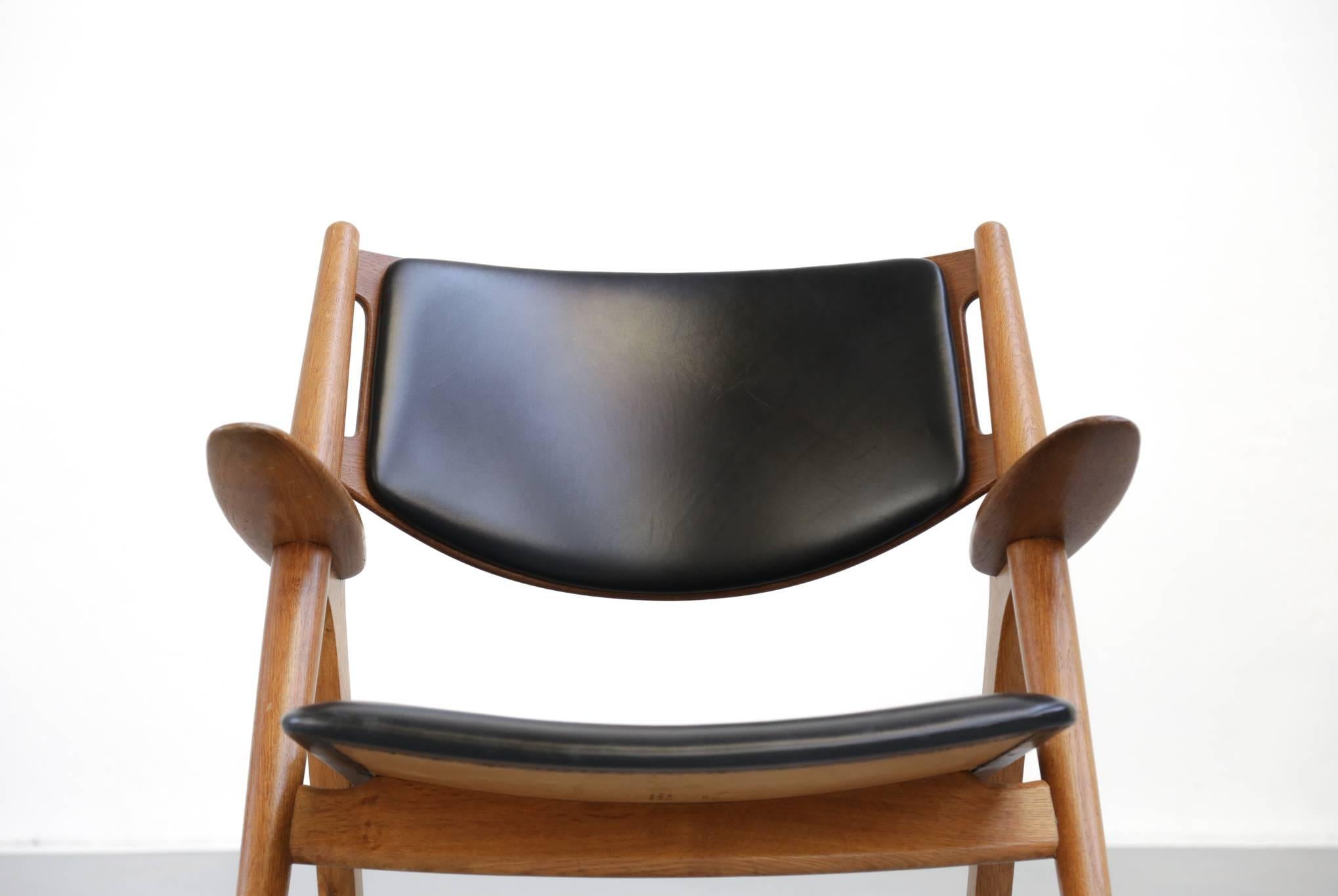 Original CH28 sawback lounge chair designed by Hans Wegner, Denmark, for Carl Hansen & Sons in massive teak. Minor sign.