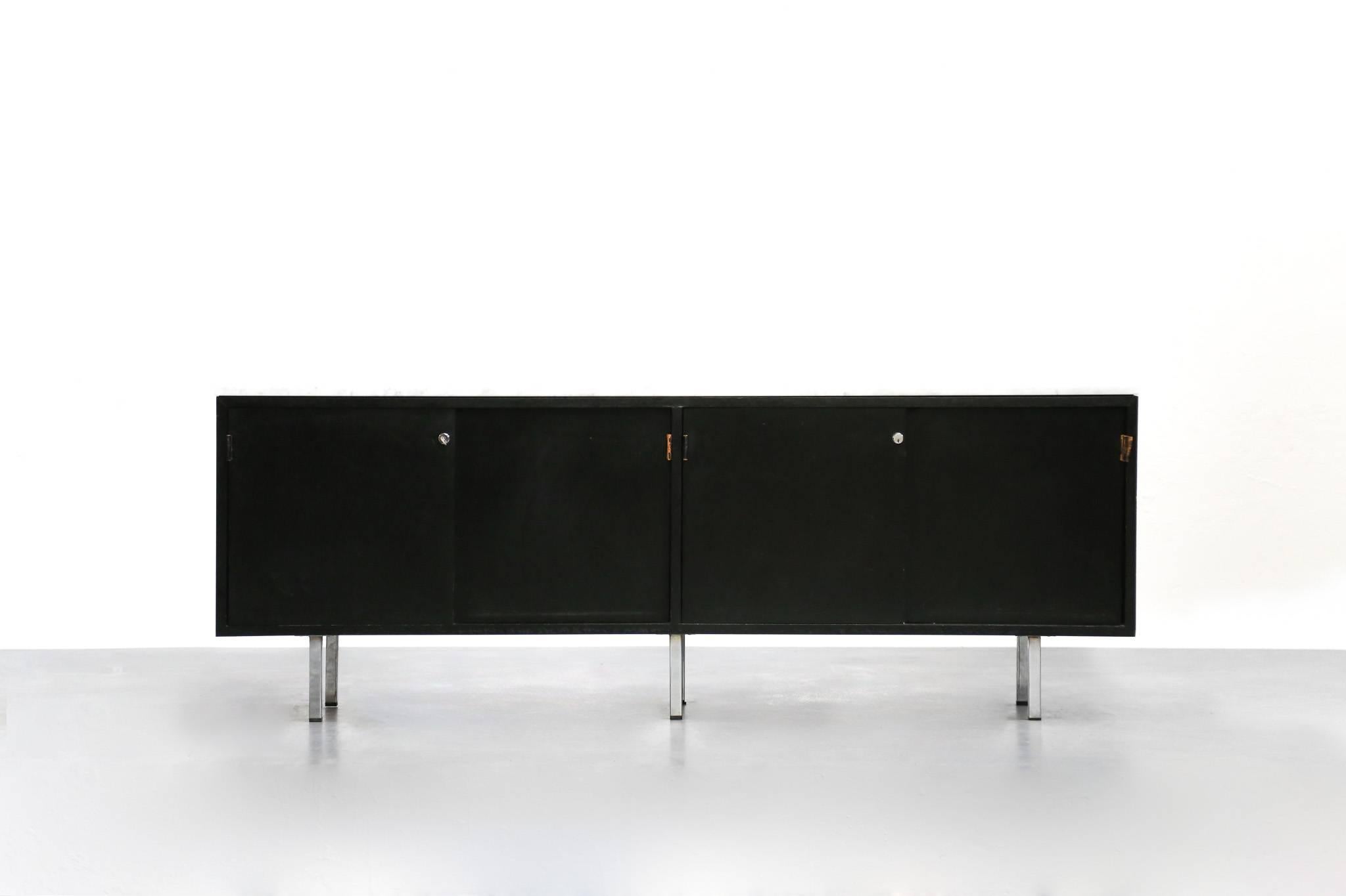 Sideboard designed by Florence Knoll for Knoll International.
Top in carrara marble and credenza lacquered oak in black. Base in chromed steel.
This model is with four sliding doors with four original leather.


 