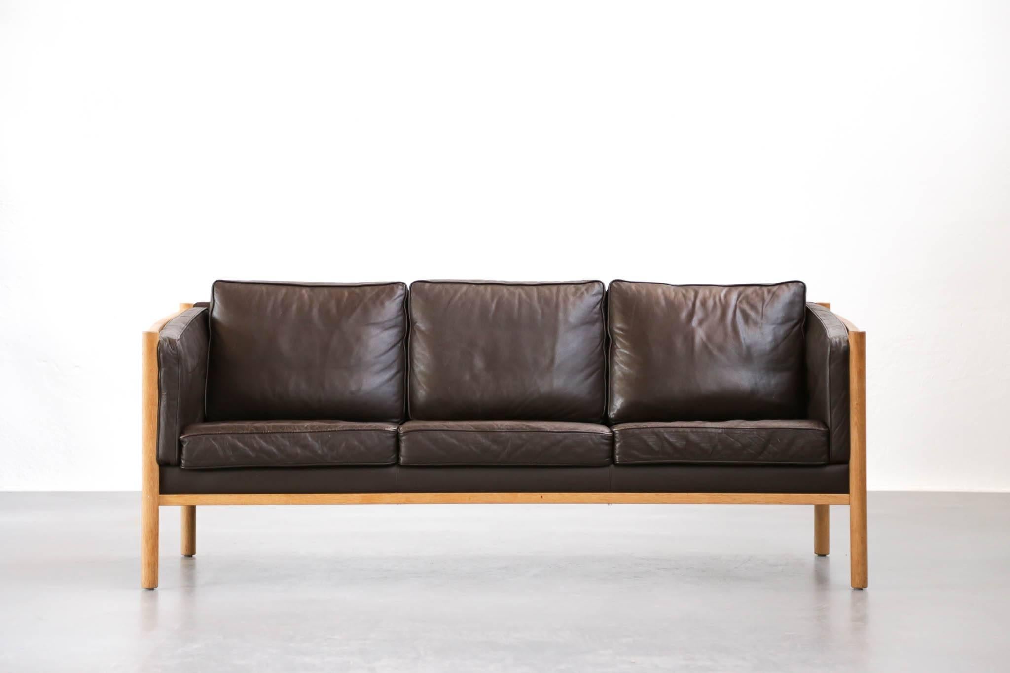 Scandinavian sofa made of oak frame and leather cushions.