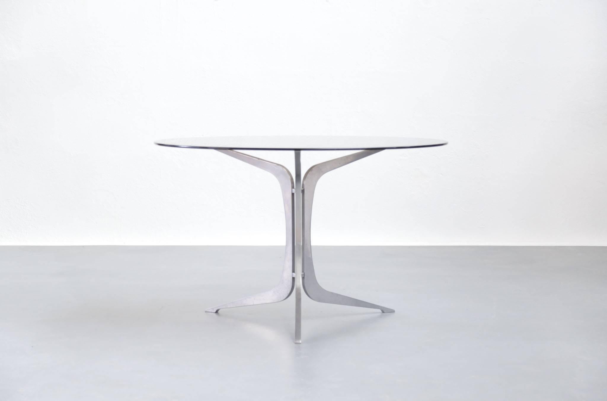 Dining table made of metal leg and smoked glass on top.