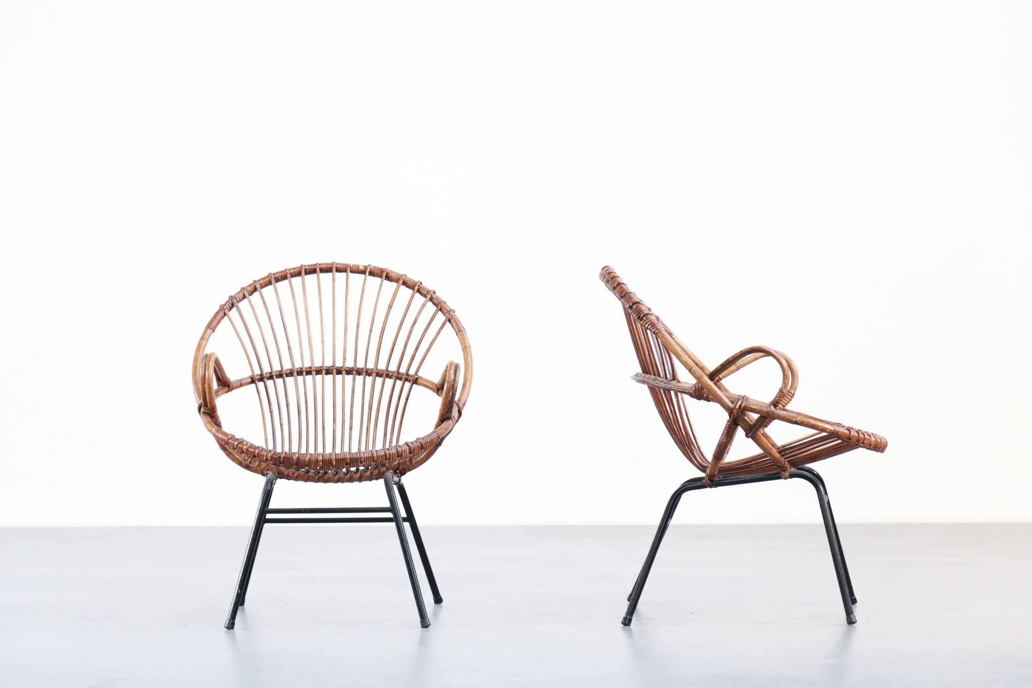 Pair of rattan armchair composed with black metal legs.