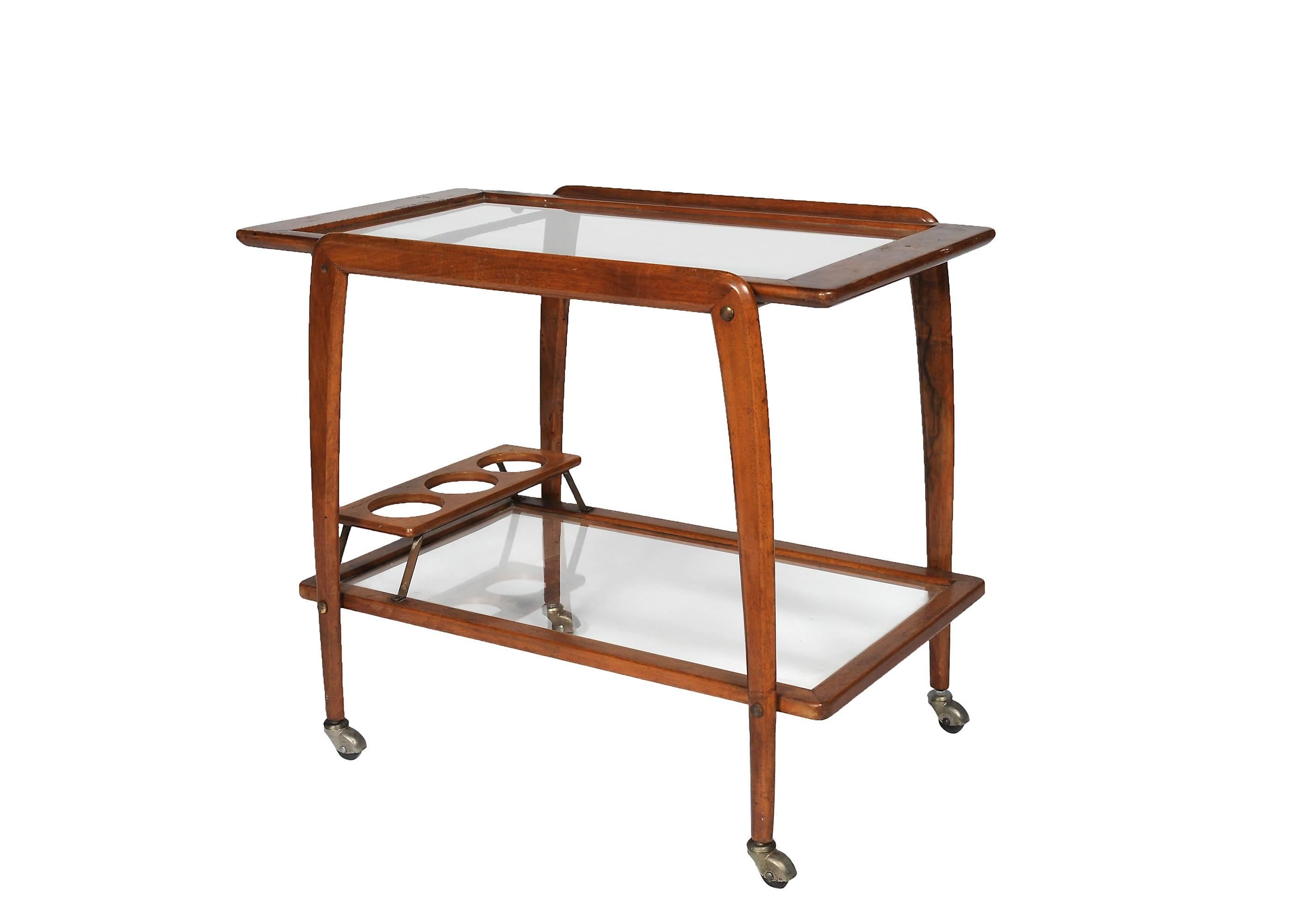 Italian Midcentury (1950s) wood walnut liquor or drinks trolley bar cart on brass wheels having a removable glass tray top and bottom shelf with three bottle holders (by Ico Parisi, Cesare Lacca for Cassina).