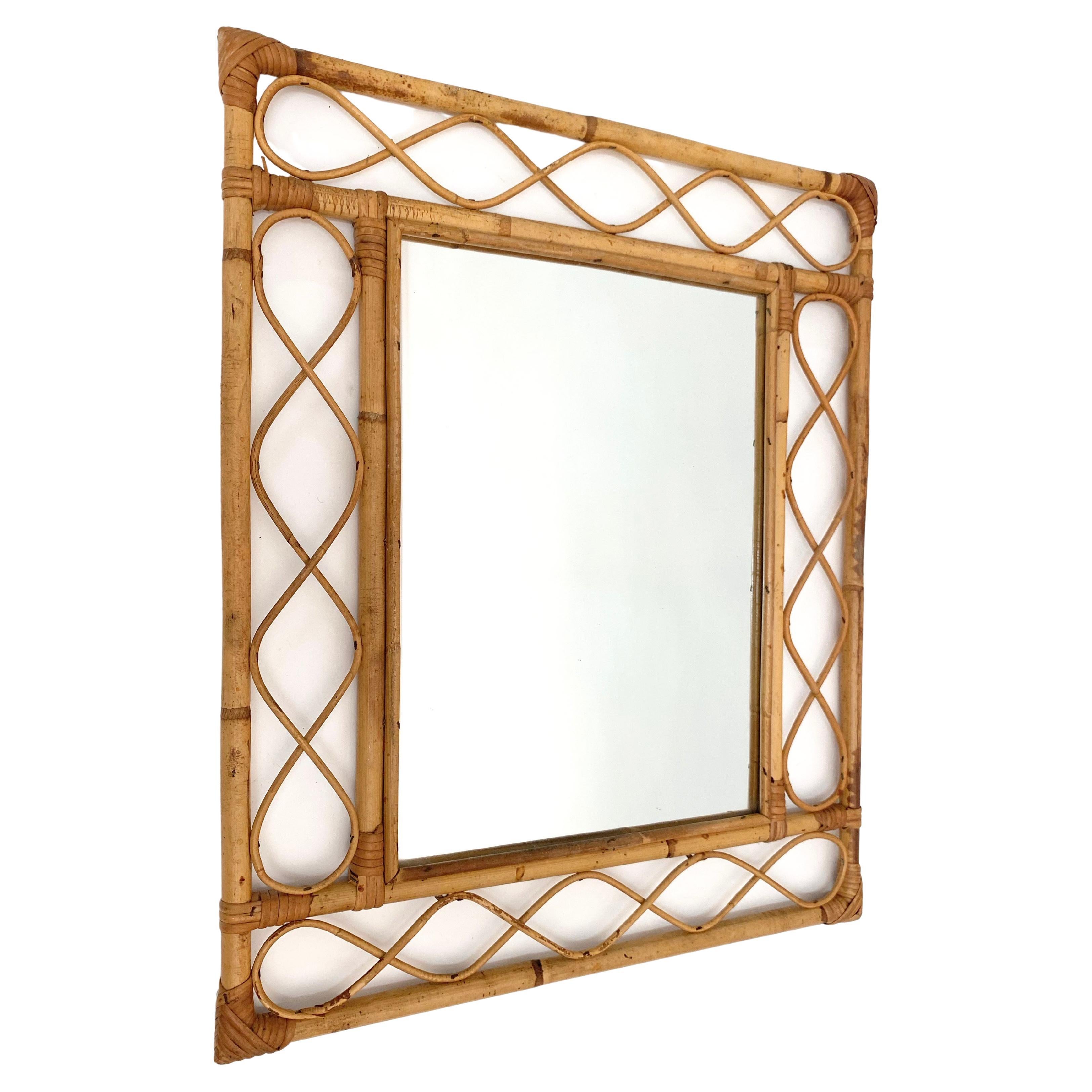 Marvellous Côte d'Azur wall mirror in bamboo and rattan. This item was produced in France during the central part of the 1960s.

The mirror its original and good vintage conditions, and the use of the materials and the lines, the straight bamboo