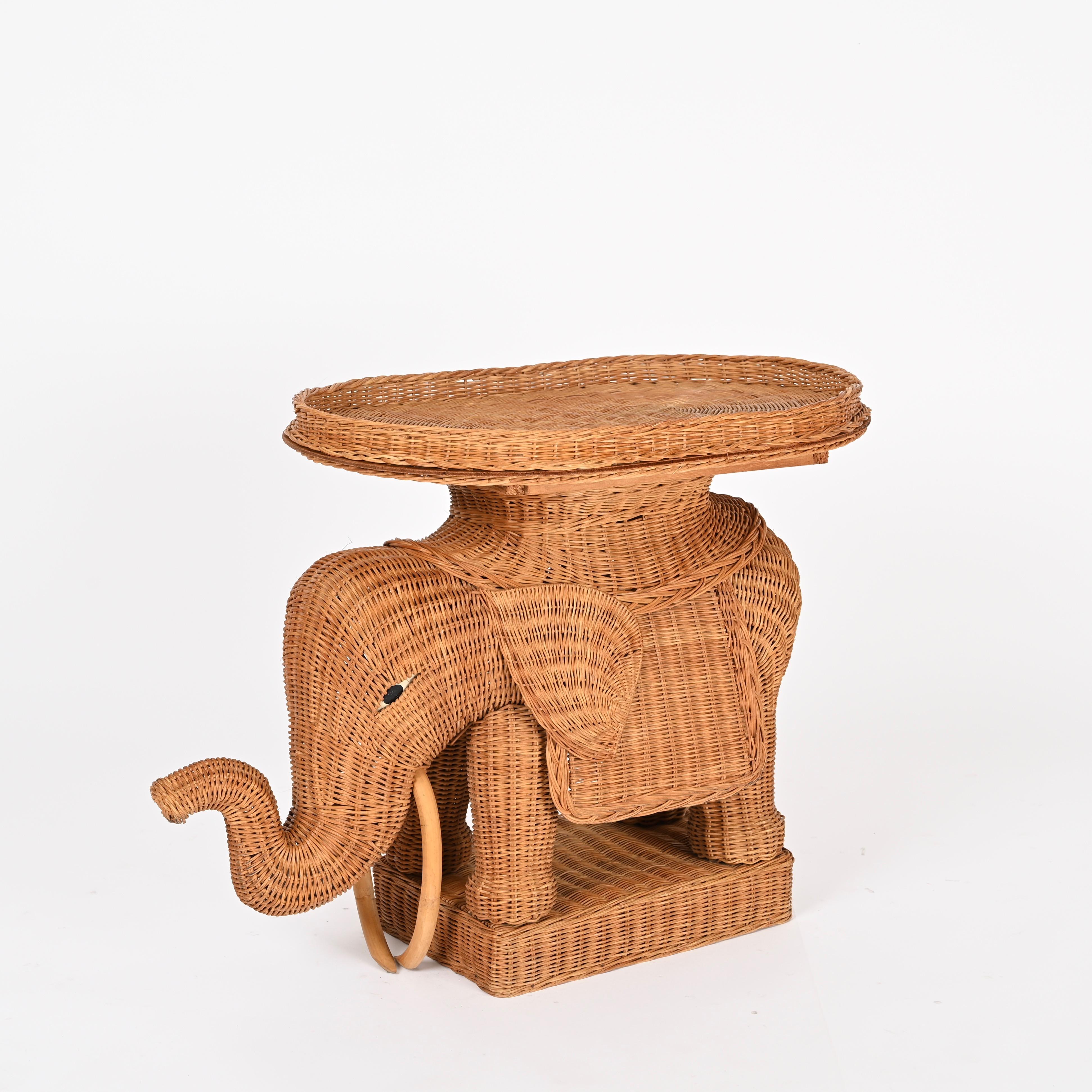 Marvelous midcentury elephant-shaped side table with removable tray fully made in hand-woven wicker. This gorgeous piece was designed by Vivai del Sud in Italy during the 1970s. 

In fabulous condition and with a charming honey color. This stylish