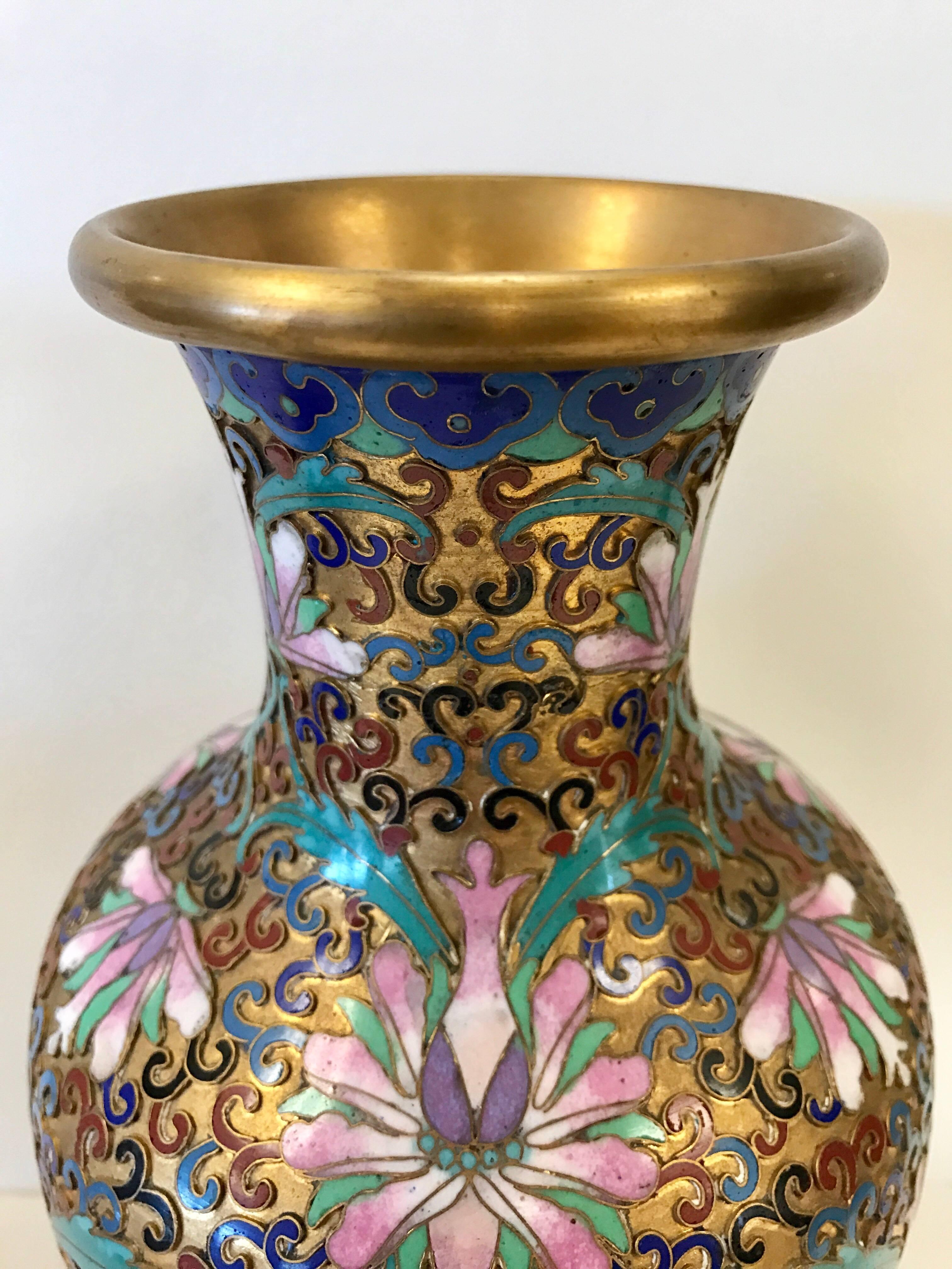 Matching pair of beautiful Chinese cloisonne urns decorated with a floral pattern all around.