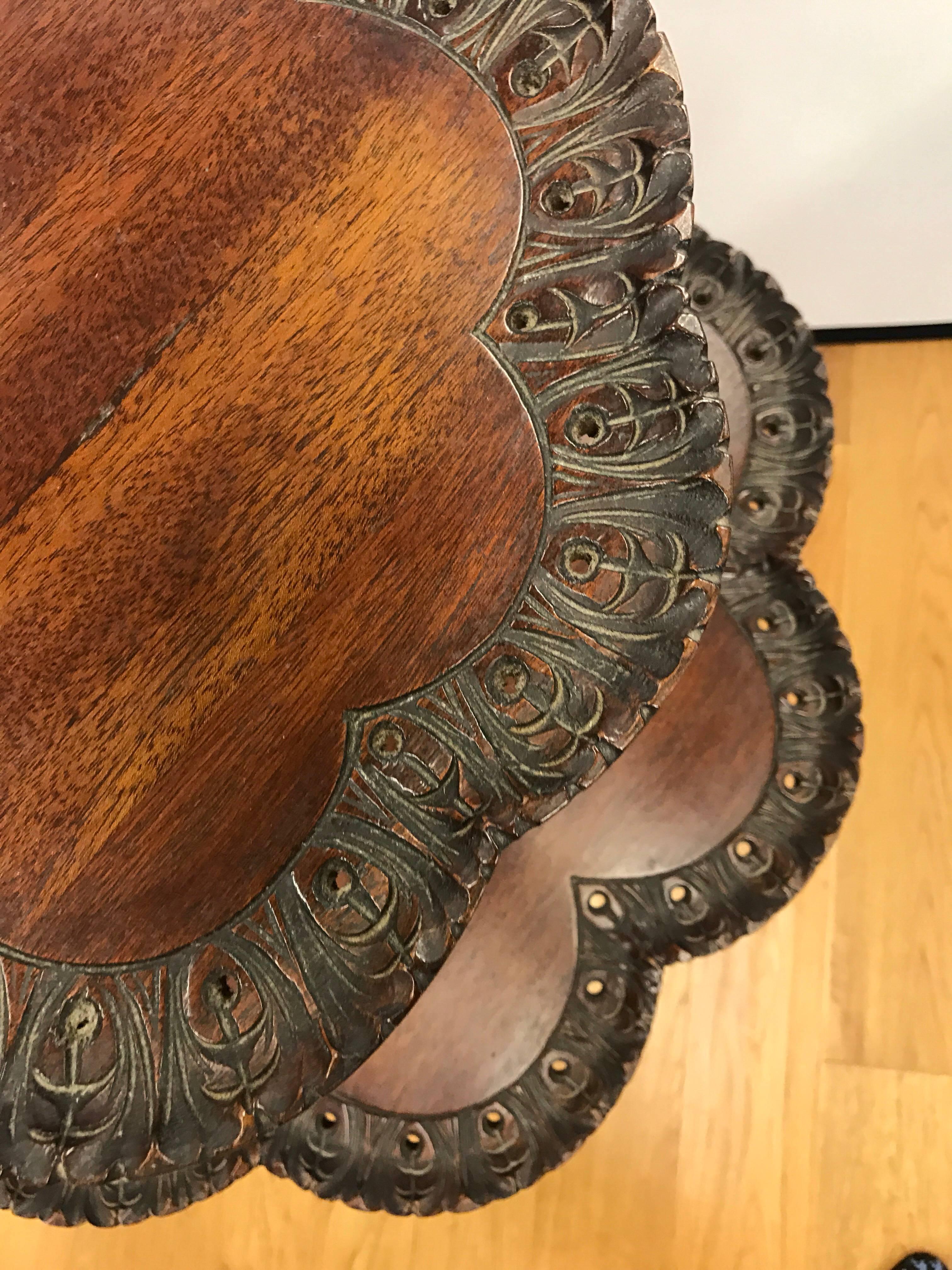 Antique Chippendale mahogany two-tiered pie crust table with carved detail on edge resting on three ball and claw feet. Pierced carvings around edge on both tiers make this a must have.