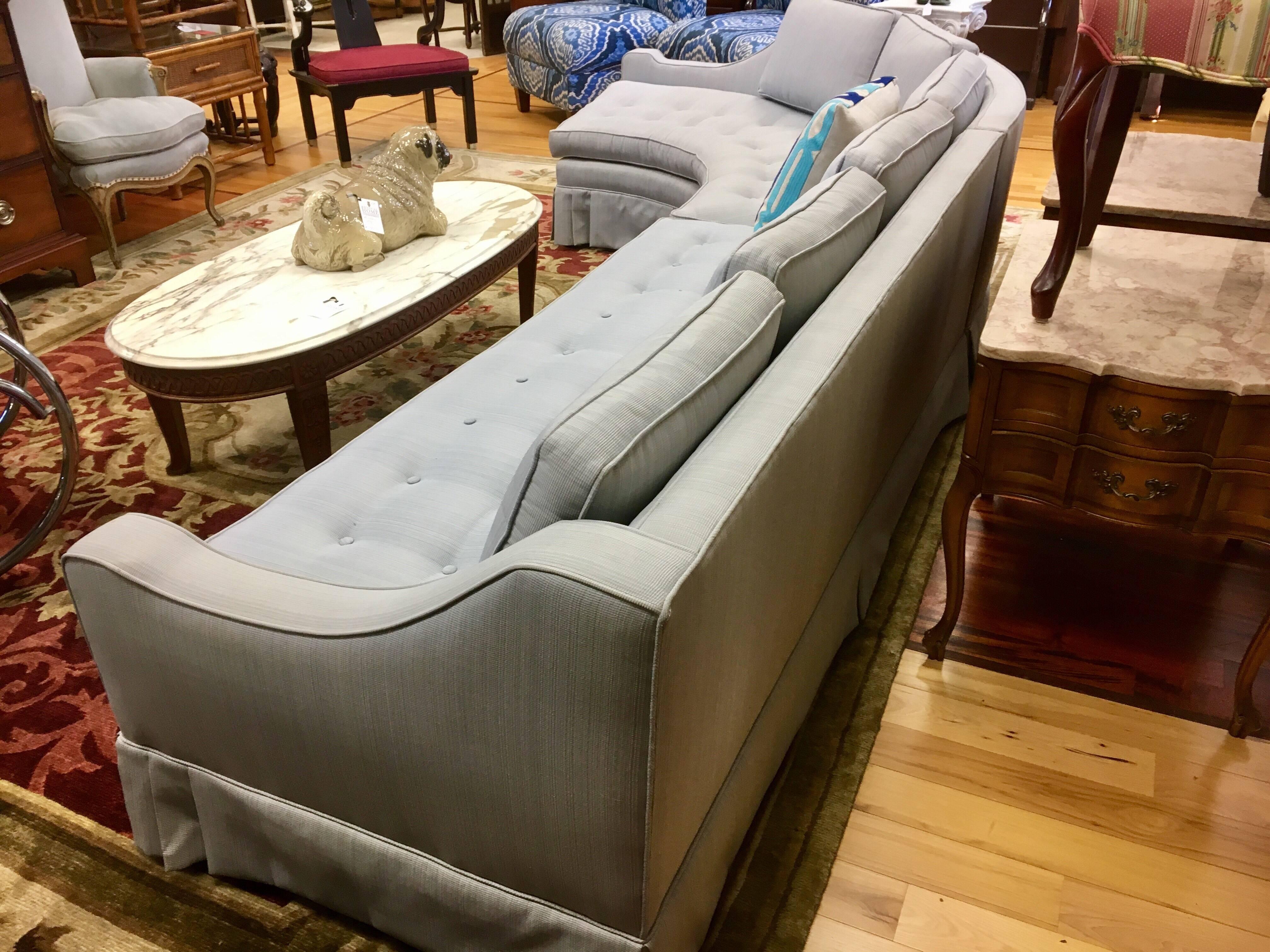 Midcentury two-piece curved sectional sofa with the palest blue upholstery in excellent condition with button tufting on the seats and pleated skirt. Six separate back cushions and two seat cushions. 
Each piece measures 72 inches long.