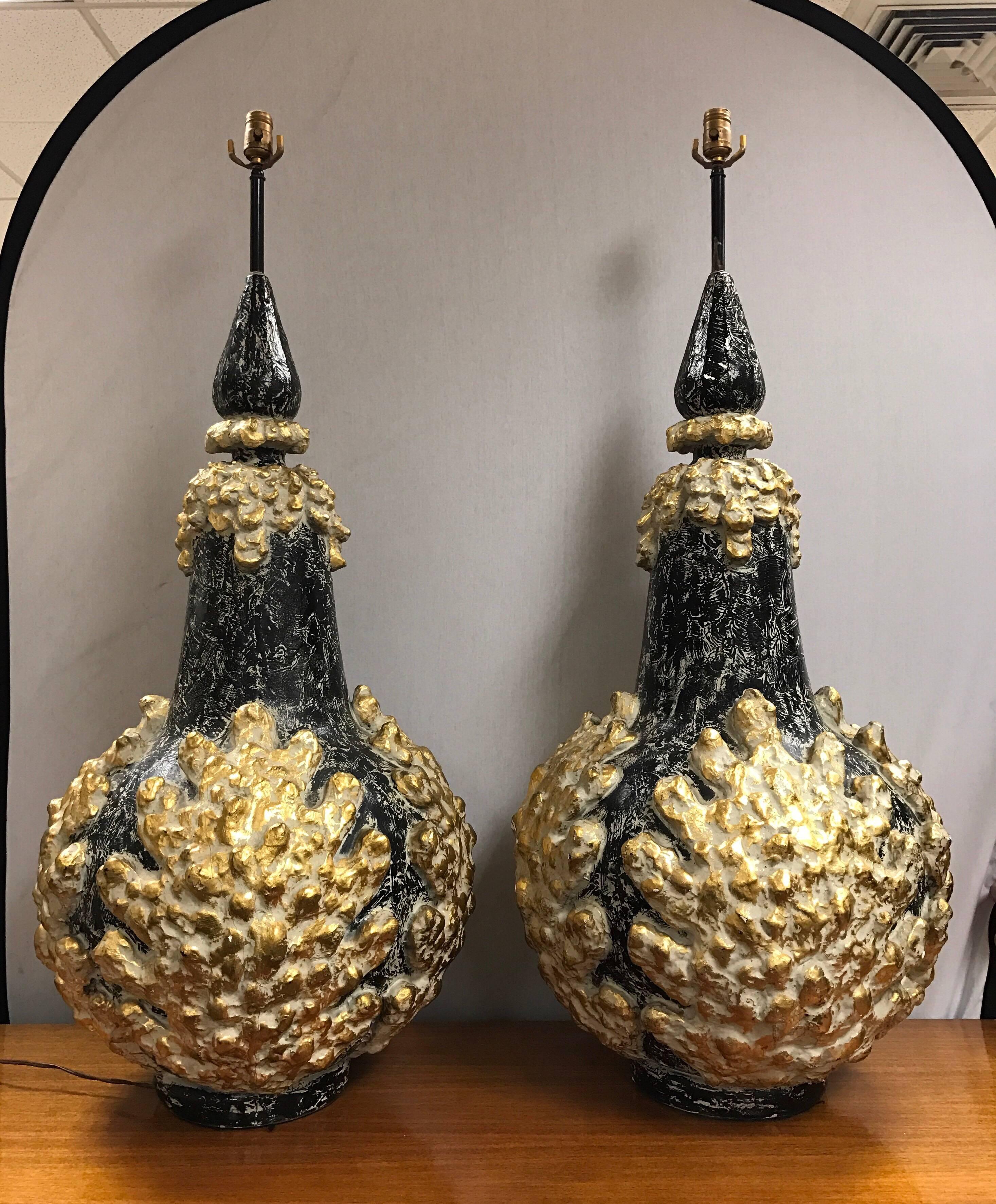 Matched pair of monumental midcentury table lamps in black and gold plaster in a textured design.
Wired for use in USA and in working condition. Very heavy at approximately 40 pounds per lamp.
One of a kind!