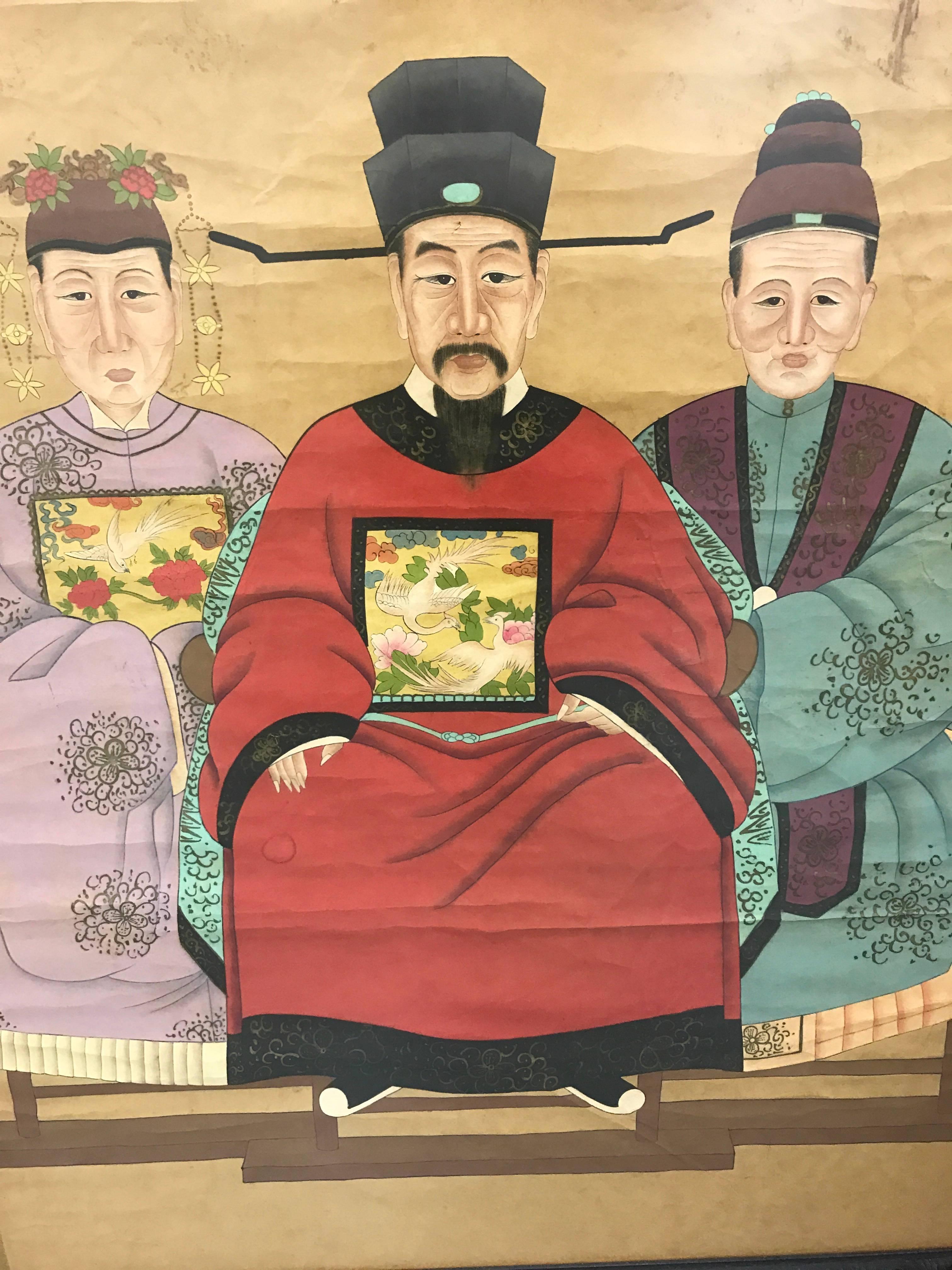 Chinese ancestral painting of three officials on paper is striking with its bold colors.
It is displayed in a carved rosewood frame and protected with plexiglass.
Overall very good condition with discoloration to background and creases/cracks.