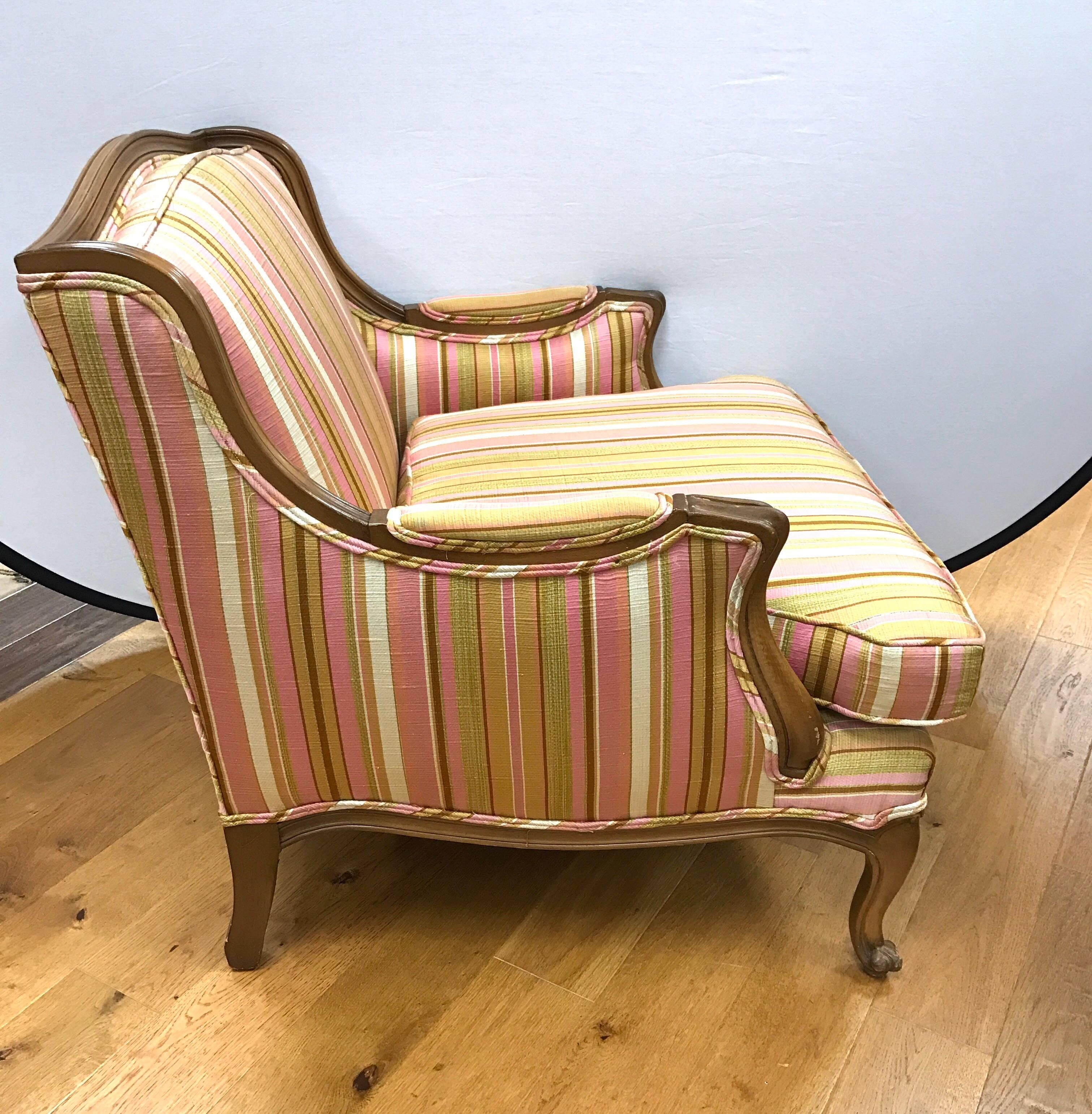 Exceptional pair of matching French bergère armchairs with an extra seat. Upholstered with pink, white and gold striped upholstery. Loose bottom cushion.