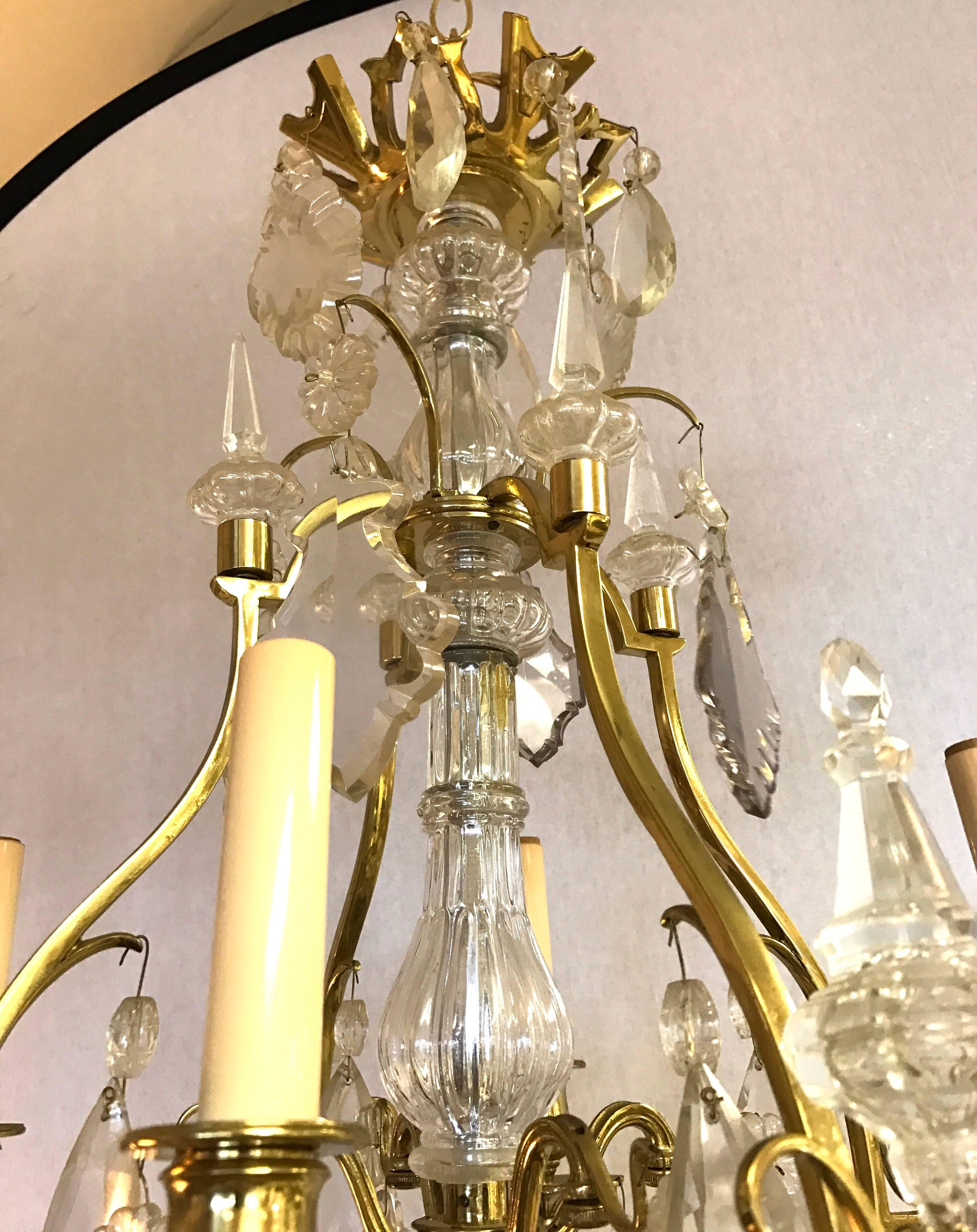 Elegant French brass and crystal chandelier with four lights and alternating crystal spires. Crystals are large and vary in size and shape. Wired for USA and in perfect working order with 24