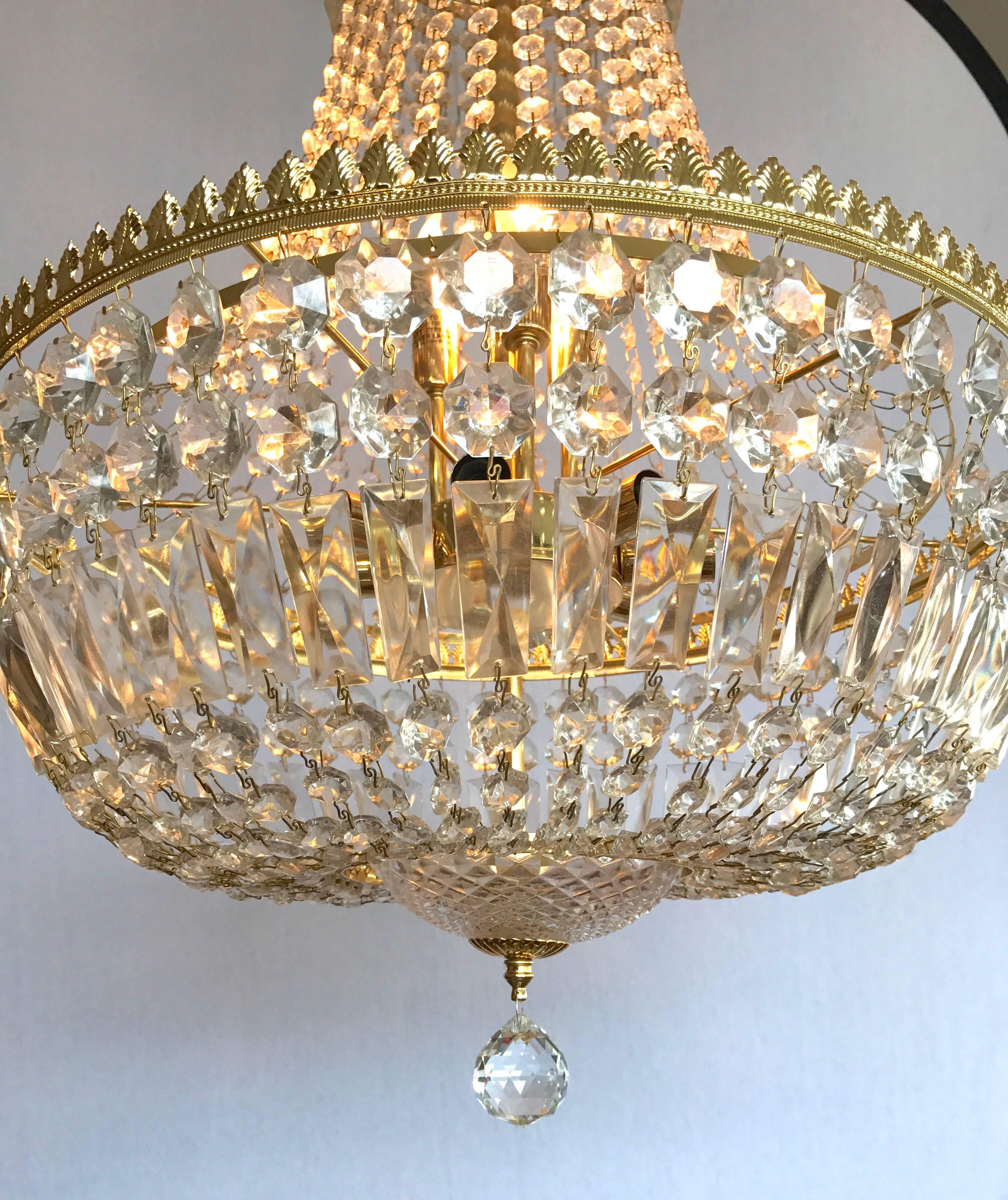 French Empire style brass and crystal basket chandelier with eleven lights, three at top and eight around the middle. Wired for USA with adjustable 28 inch chain.