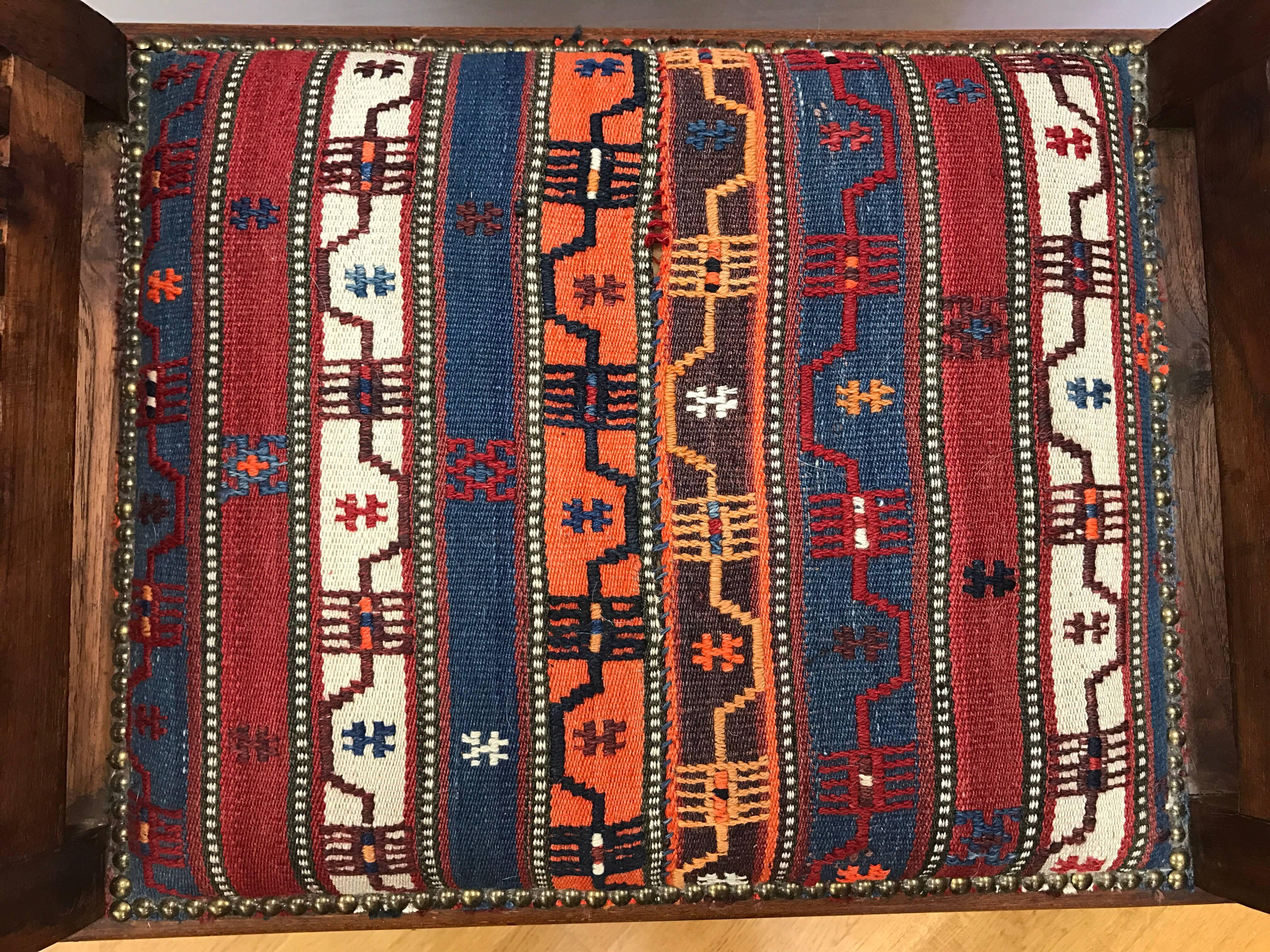 Teak curule bench with slatted sides upholstered with a Kilim seat and finished with brass nailheads.