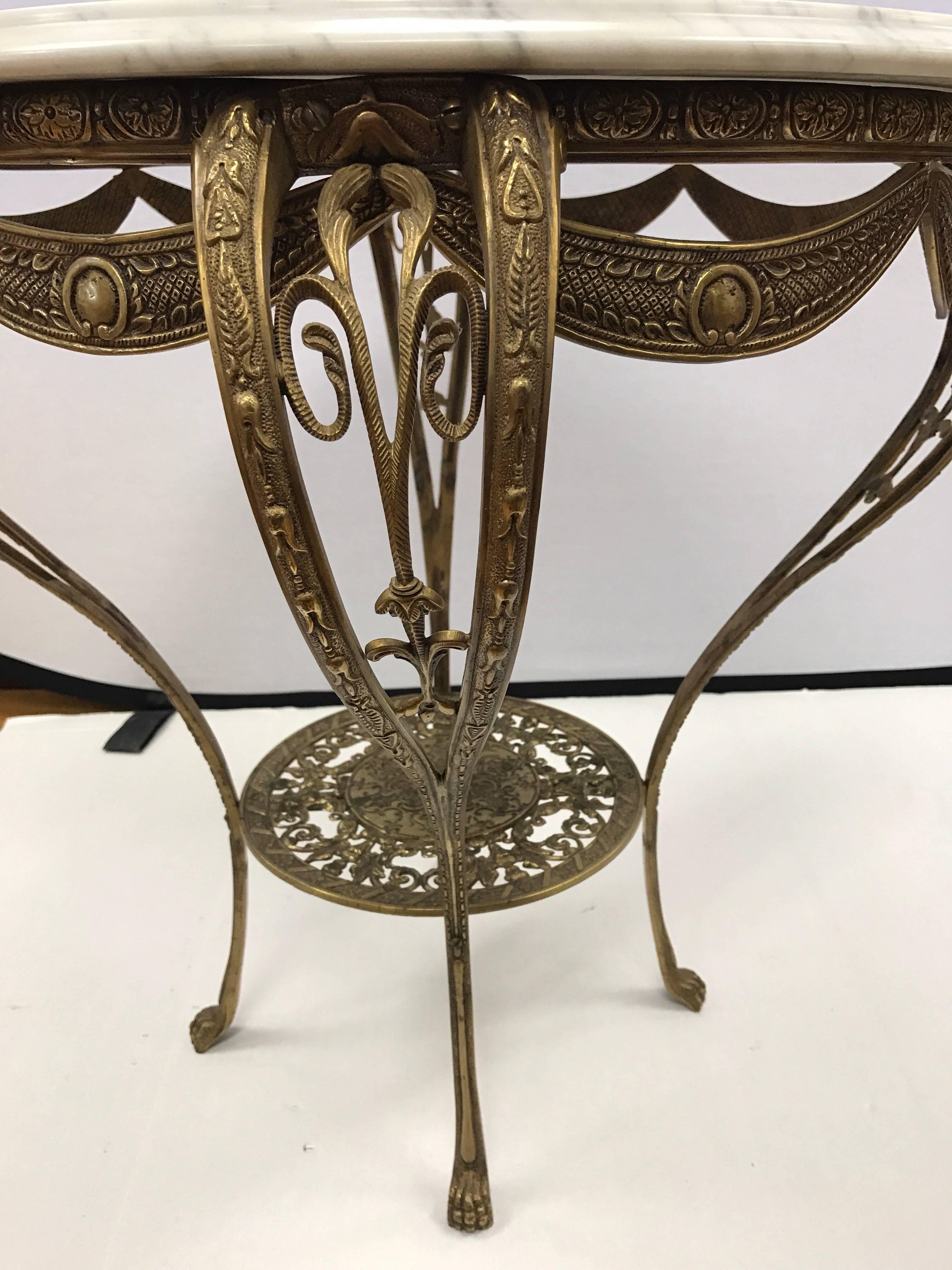 Elegant brass and marble round table made in Italy.  The terrific scale of this piece makes it a must have that can fit anywhere. The incised gold design over the marble top and elaborate brass work really set this table apart.

