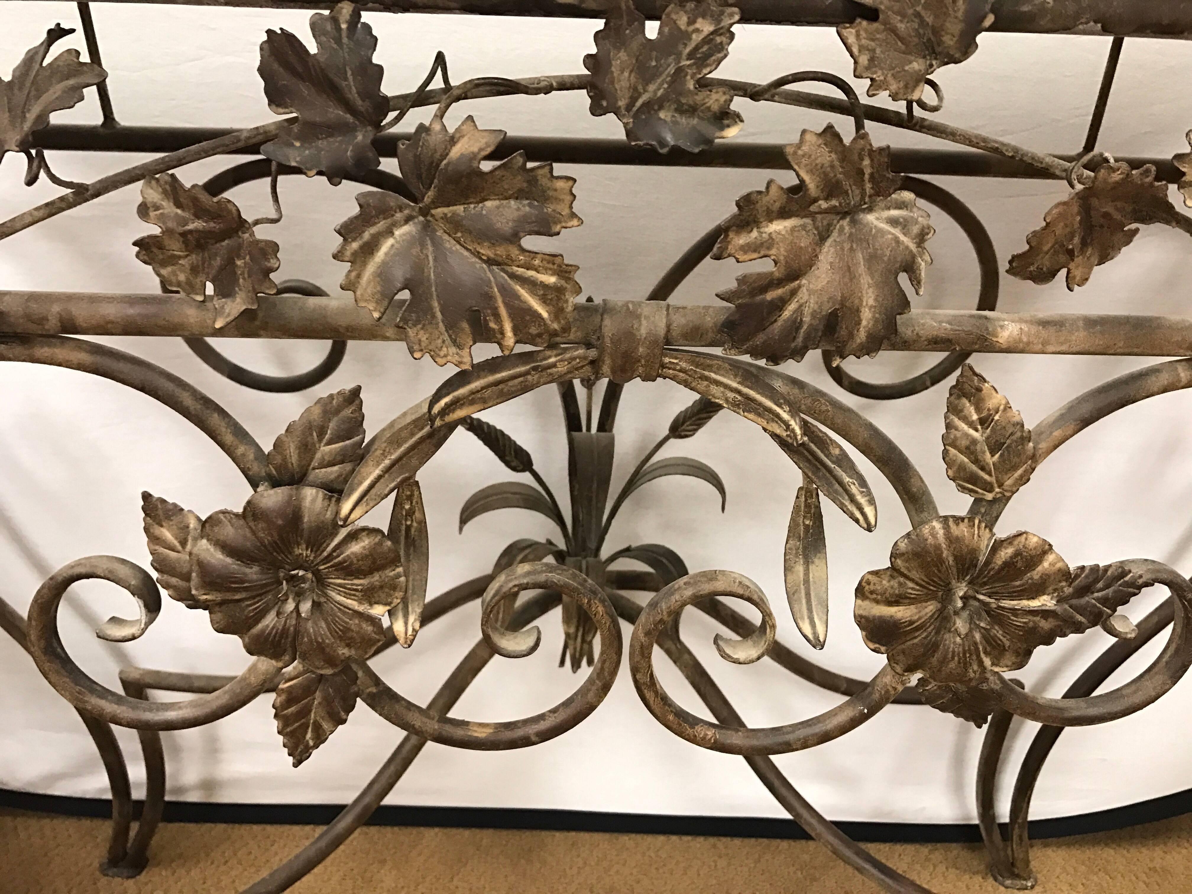 Custom made gold iron console table has a cream marble top with scrolled metal work of flowers and wheat sheaves. The metal work is unusual and quite elaborate.