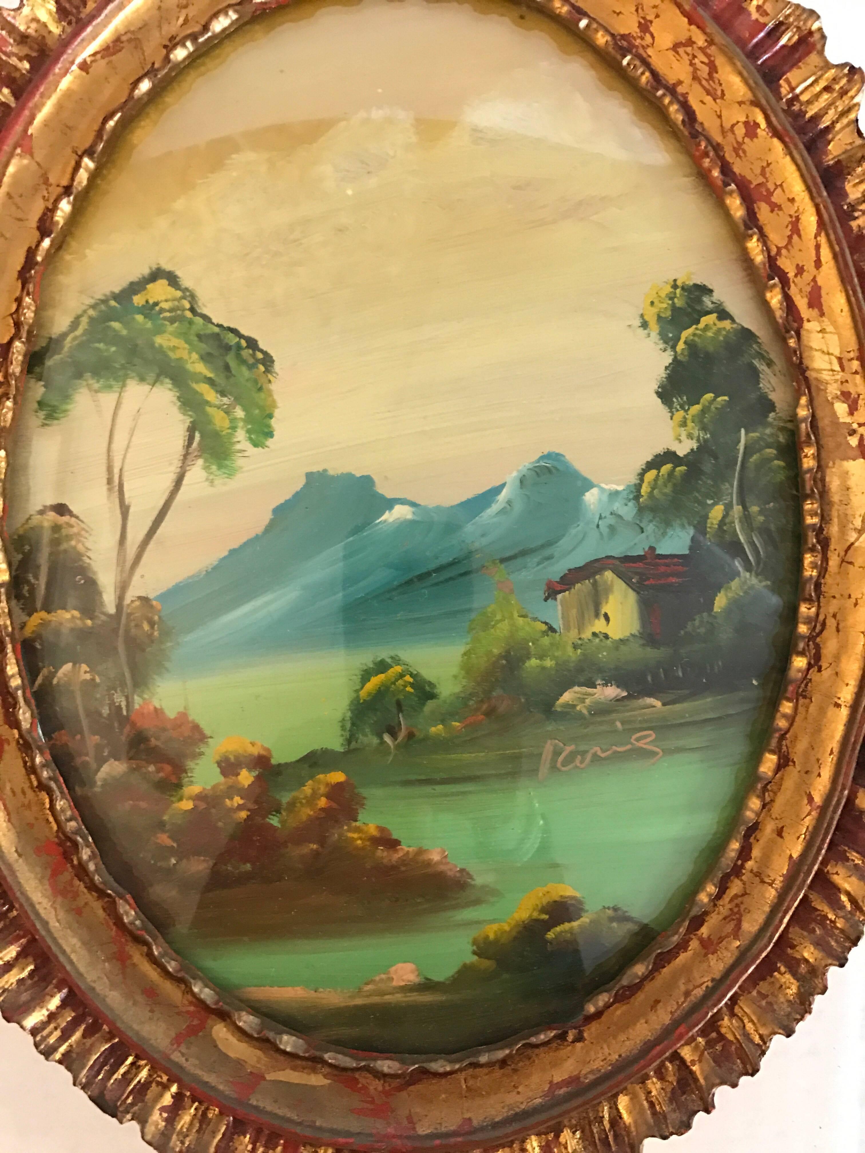 Pair of 19th century Italian oval landscape oil paintings under glass and displayed in carved giltwood frames.  Medium is oil on canvas and glass is slightly convex.  The painting that shows two sailboats is signed on the bottom left by the artist