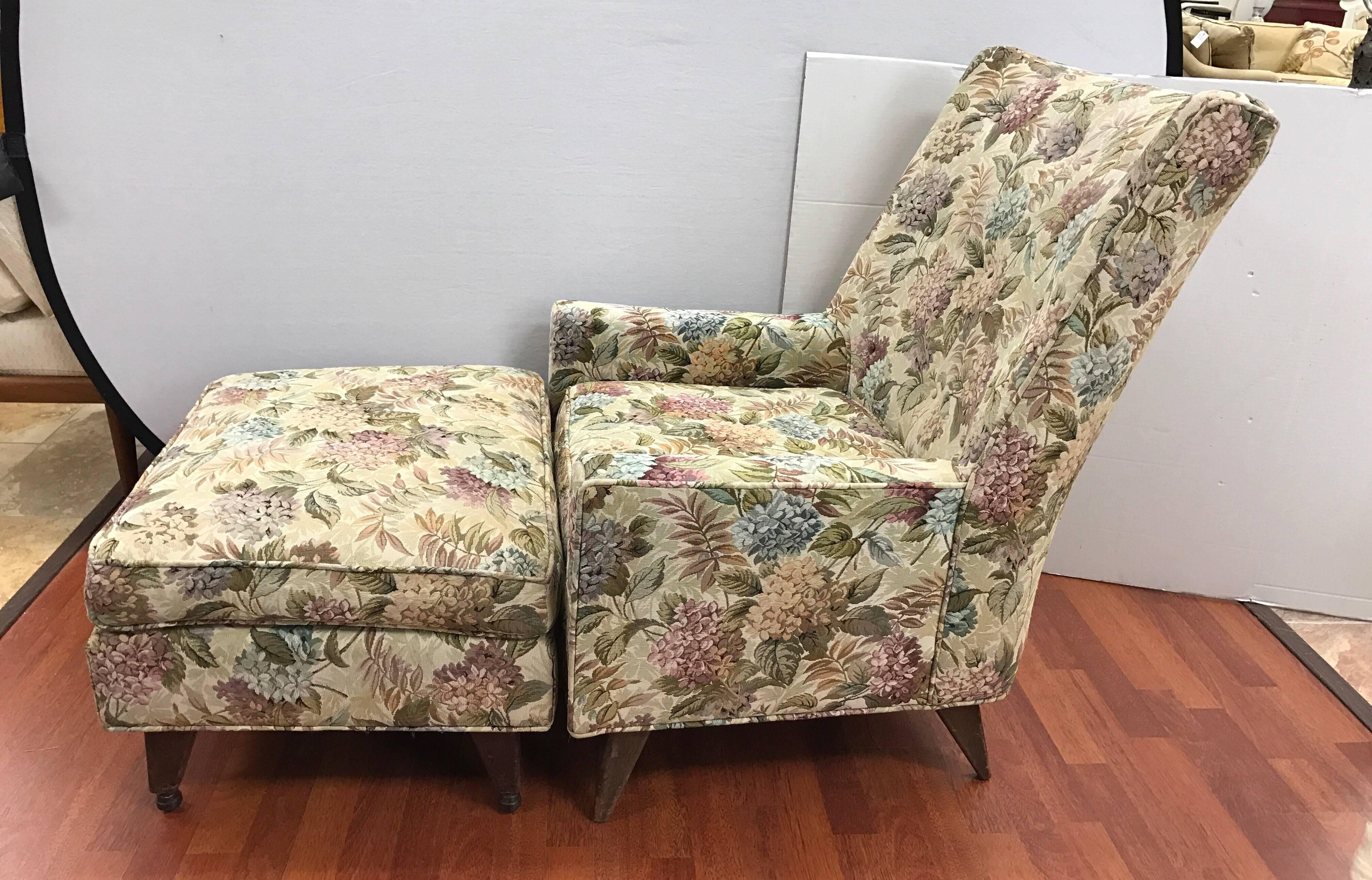 1960s upholstered lounge chair and ottoman that features casters for ease of movement. Original floral tapestry upholstery.