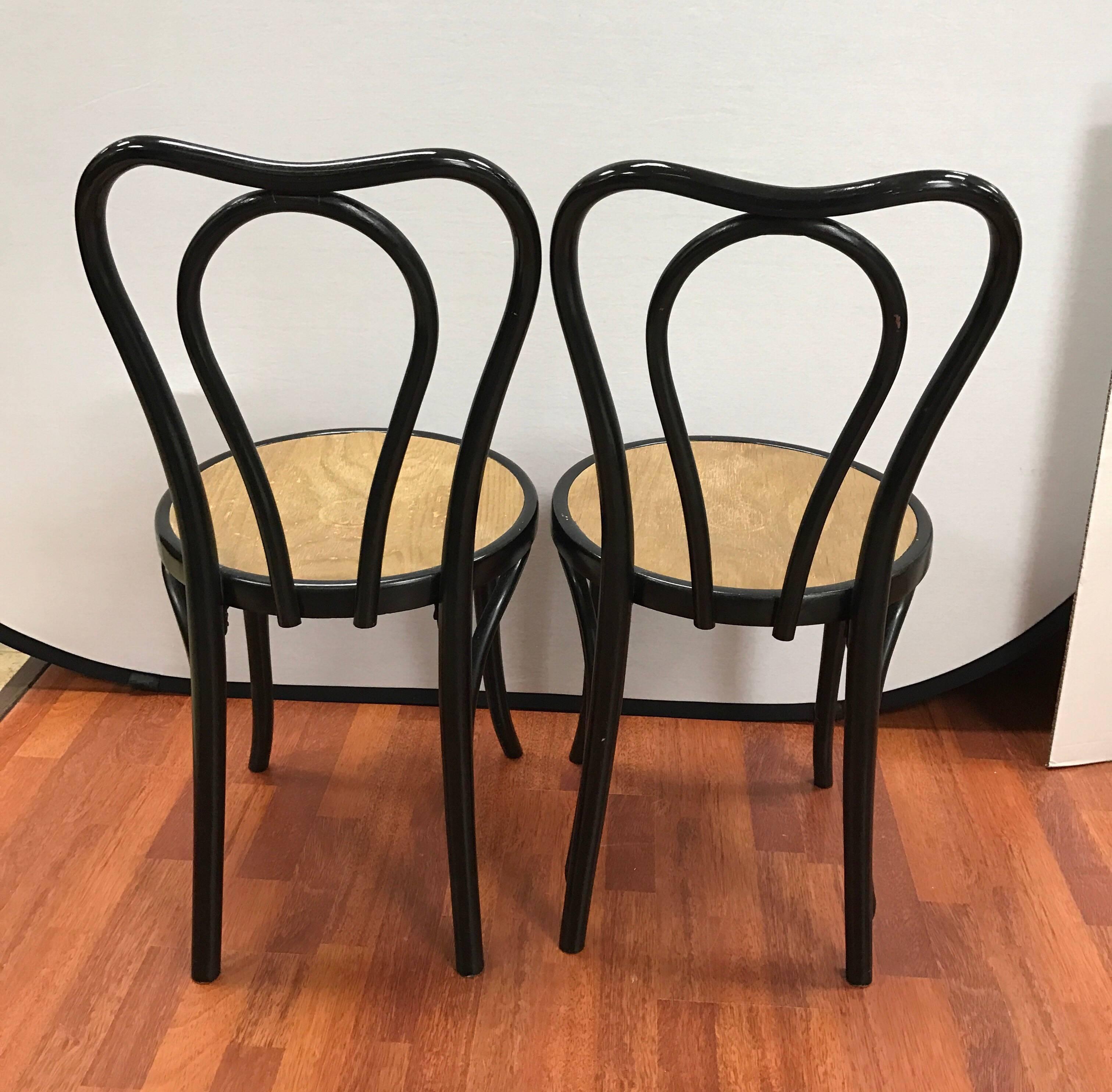 Pair of black Thonet style bentwood chairs with pressed seat.