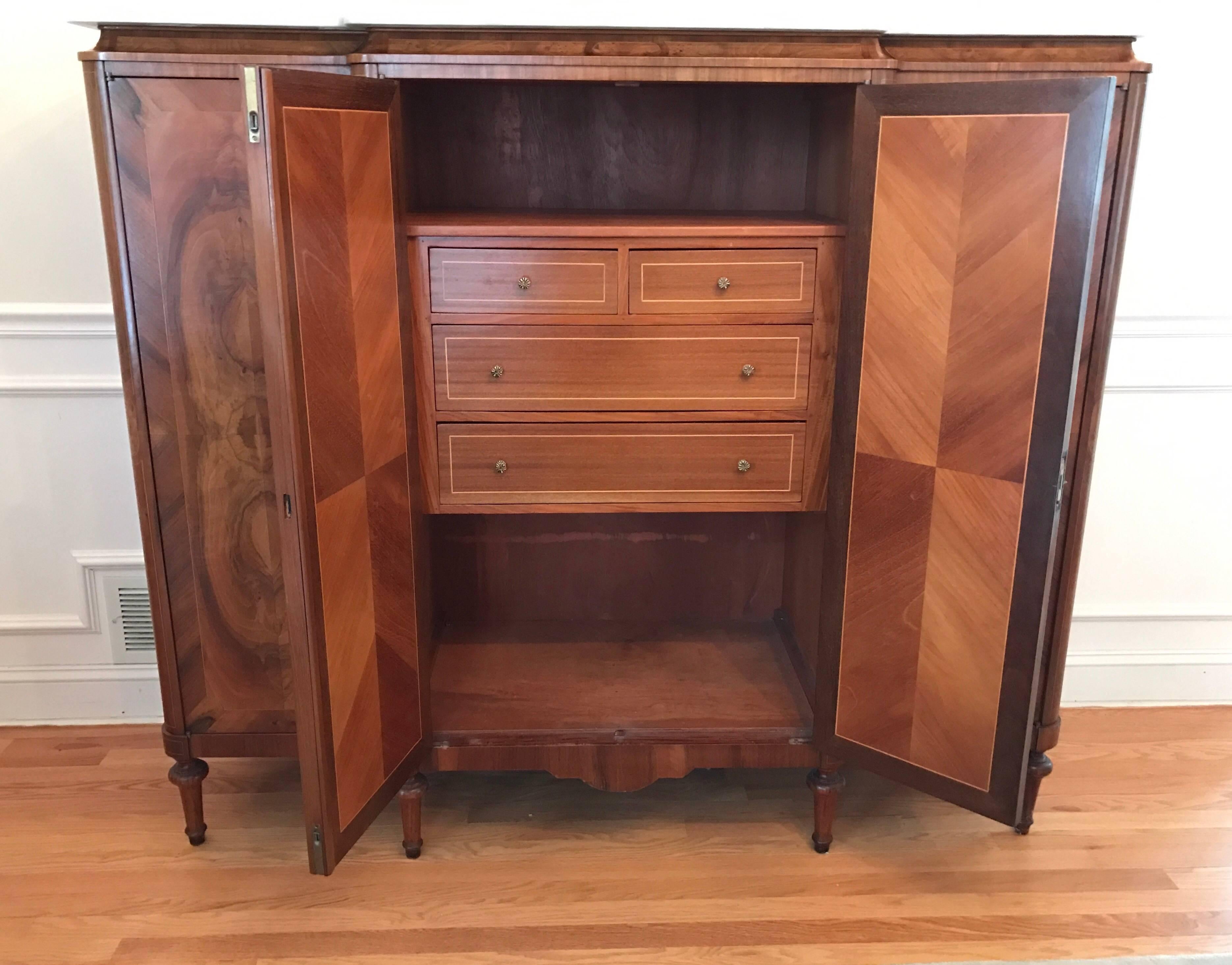 In the style of Mercier Freres, this 1920s, French piece can function as a cabinet, credenza or sideboard. The crotch mahogany is absolutely beautiful and covers the front doors and sides. All three doors have working lock and keys. It is tall, but