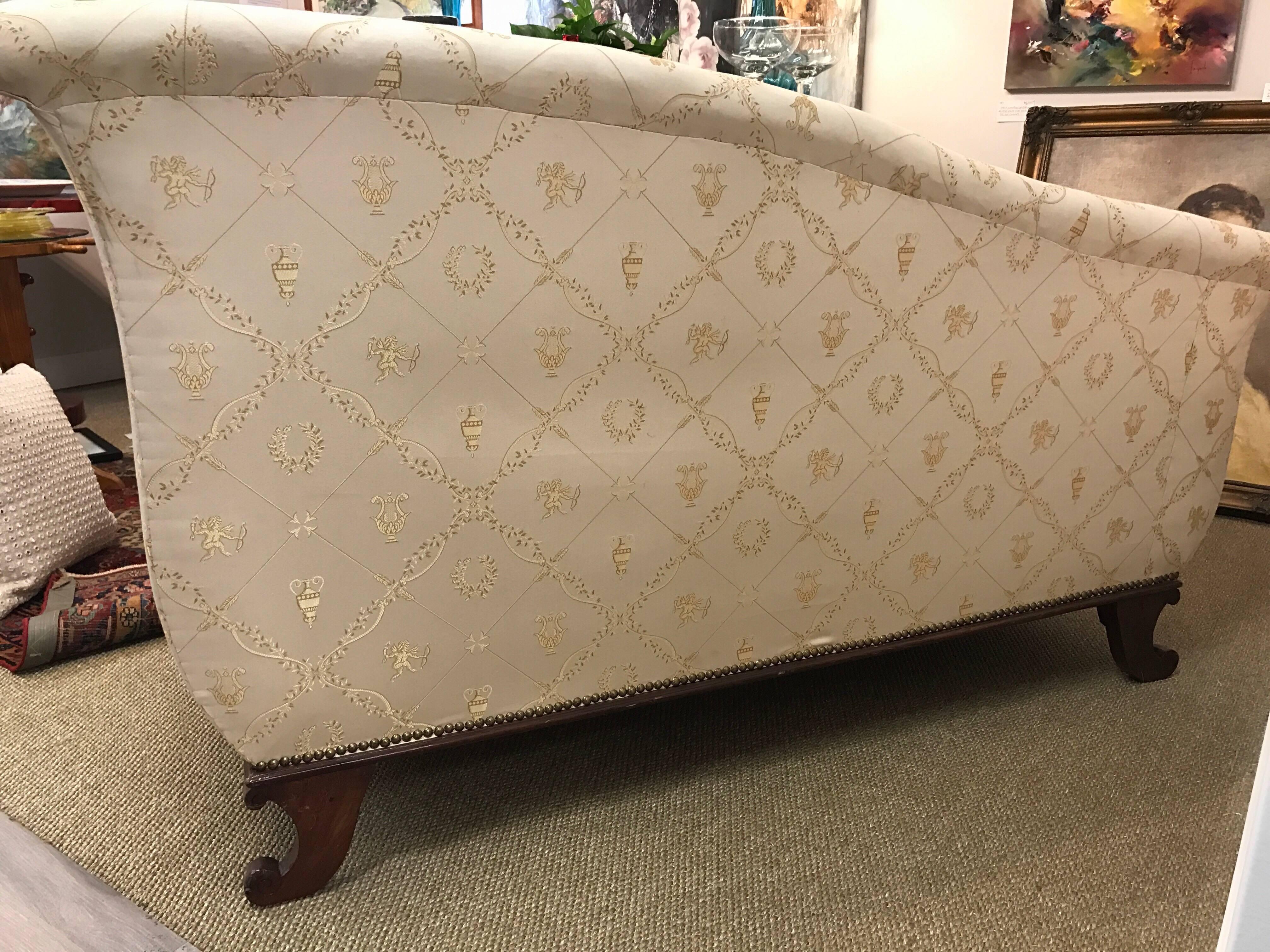 19th Century French recamier has a polished mahogany frame and is upholstered in a luxurious cream silk fabric with gold threading. Down filled cushion and brass nailheads all around. Bolster pillow included.  Minor scratches, chips due to age.