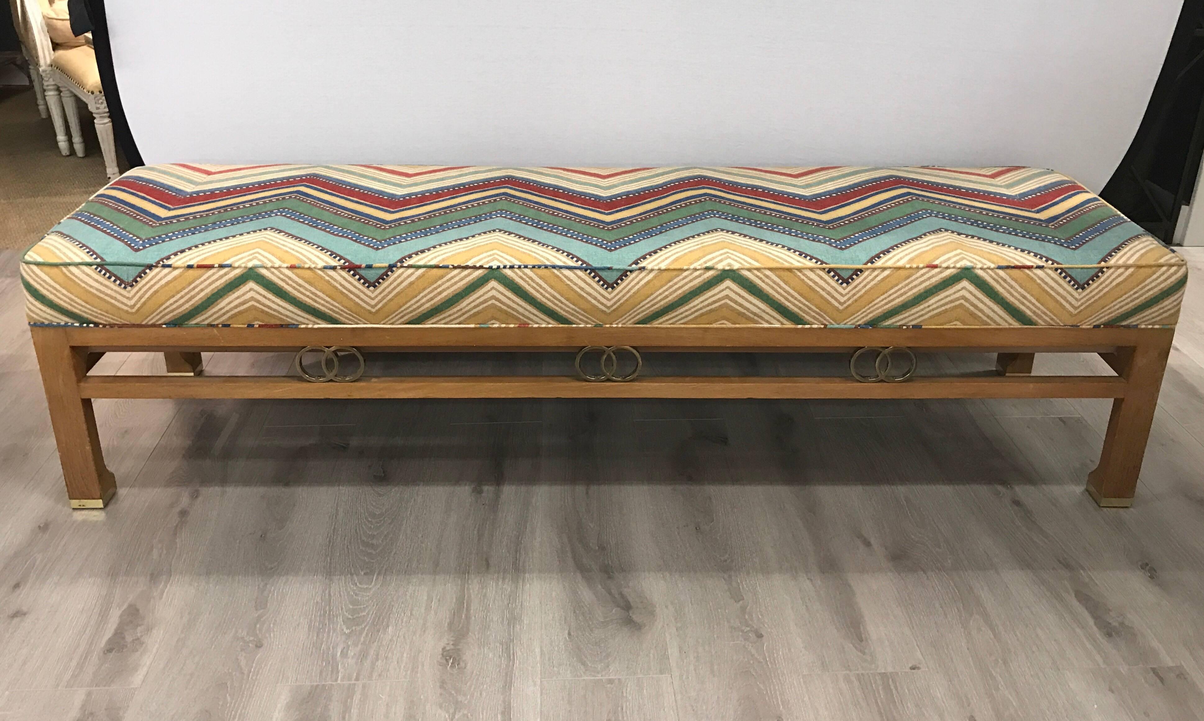 James Mont Style long bench with brass ring detail. Newly upholstered in Osborne and Little fabric. Perfect at the foot of a bed or in a foyer or hallway.