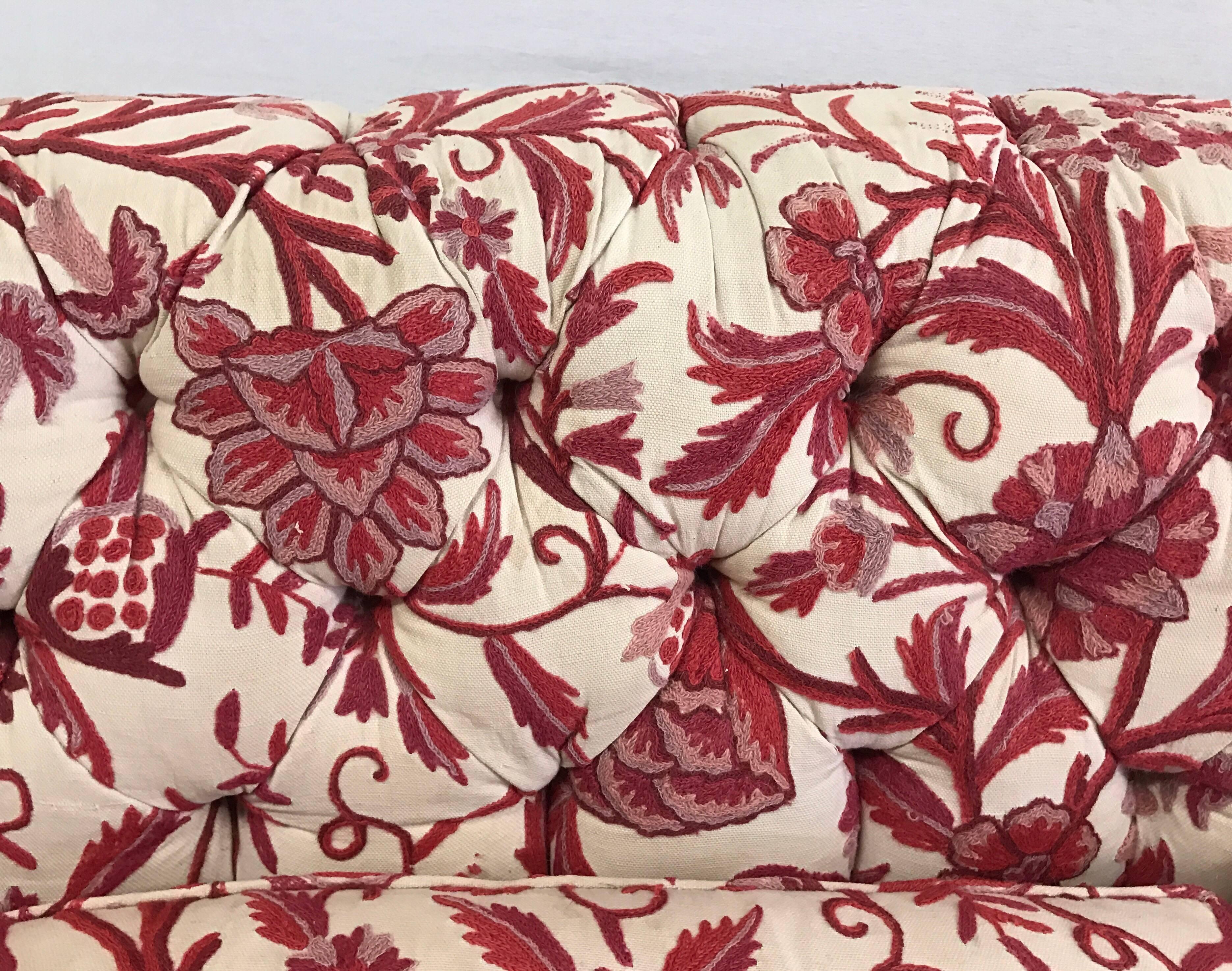 A vintage button tufted chesterfield sofa upholstered in a red and white crewel fabric by Brunschwig and Fil. 