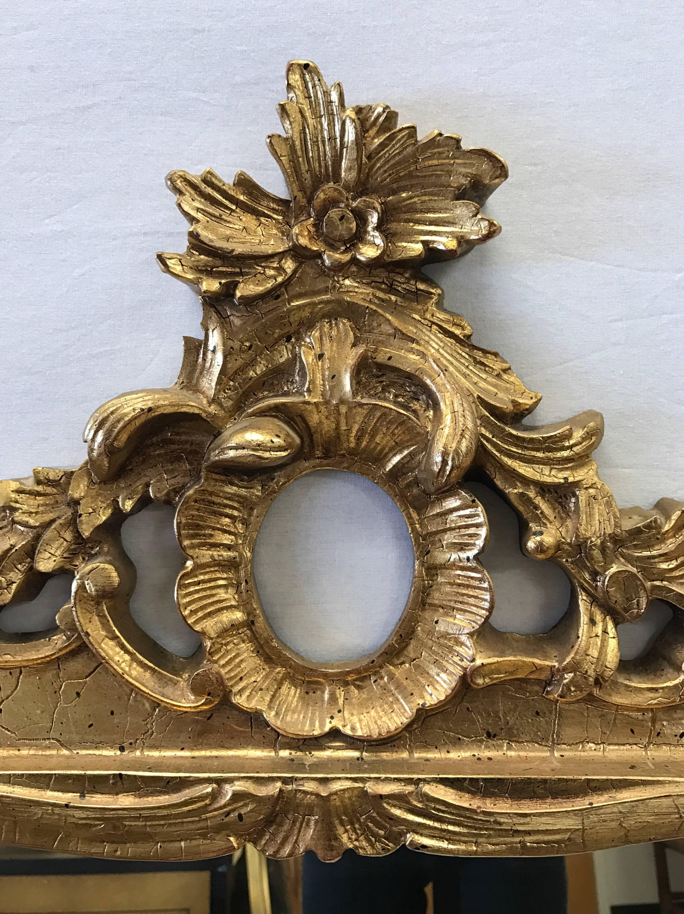 Exquisite 20th century French carved giltwood mirror with scroll and foliate detail.