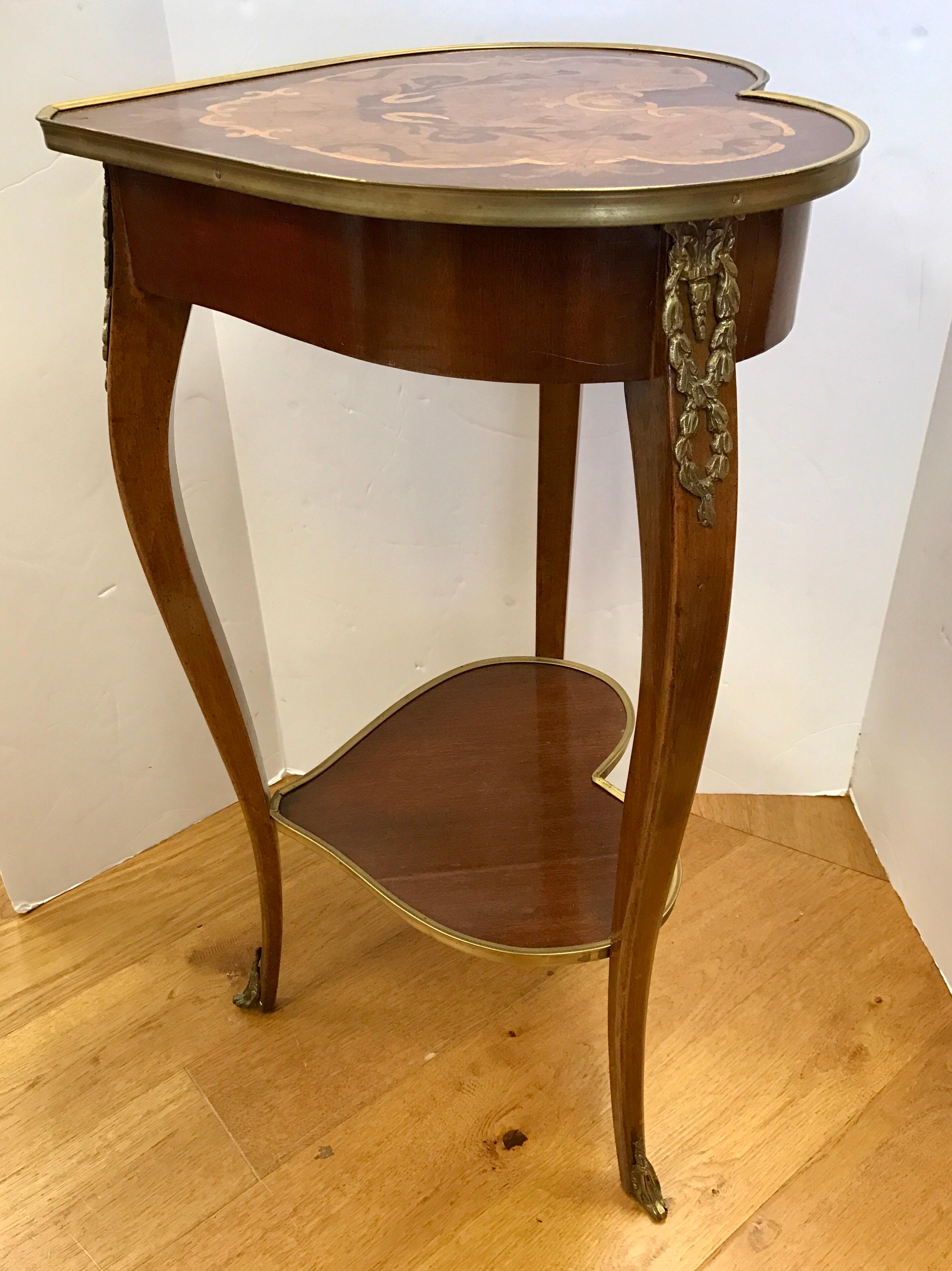 Small in scale but a giant in terms of style, this Louis XV heart shaped table has two tiers and marquetry throughout as well as bronze ormolu.