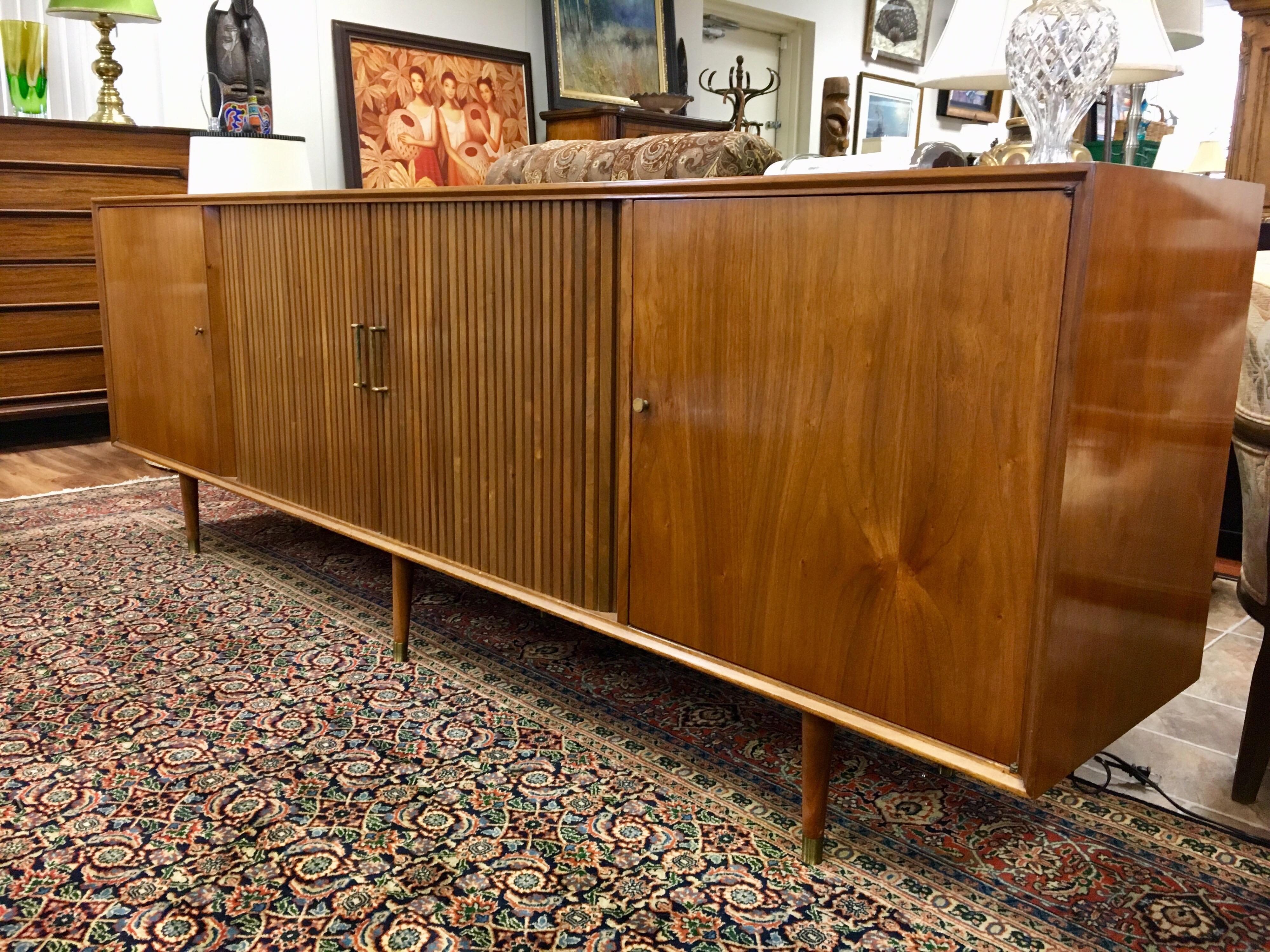 Mid century modern long buffet/credenza. It measures eight feet long and has sliding doors at middle. Side doors open to drawers and shelving. Made by NY Mid-Century Modern furniture maker Furnette in the 1960s. All hallmarks present.