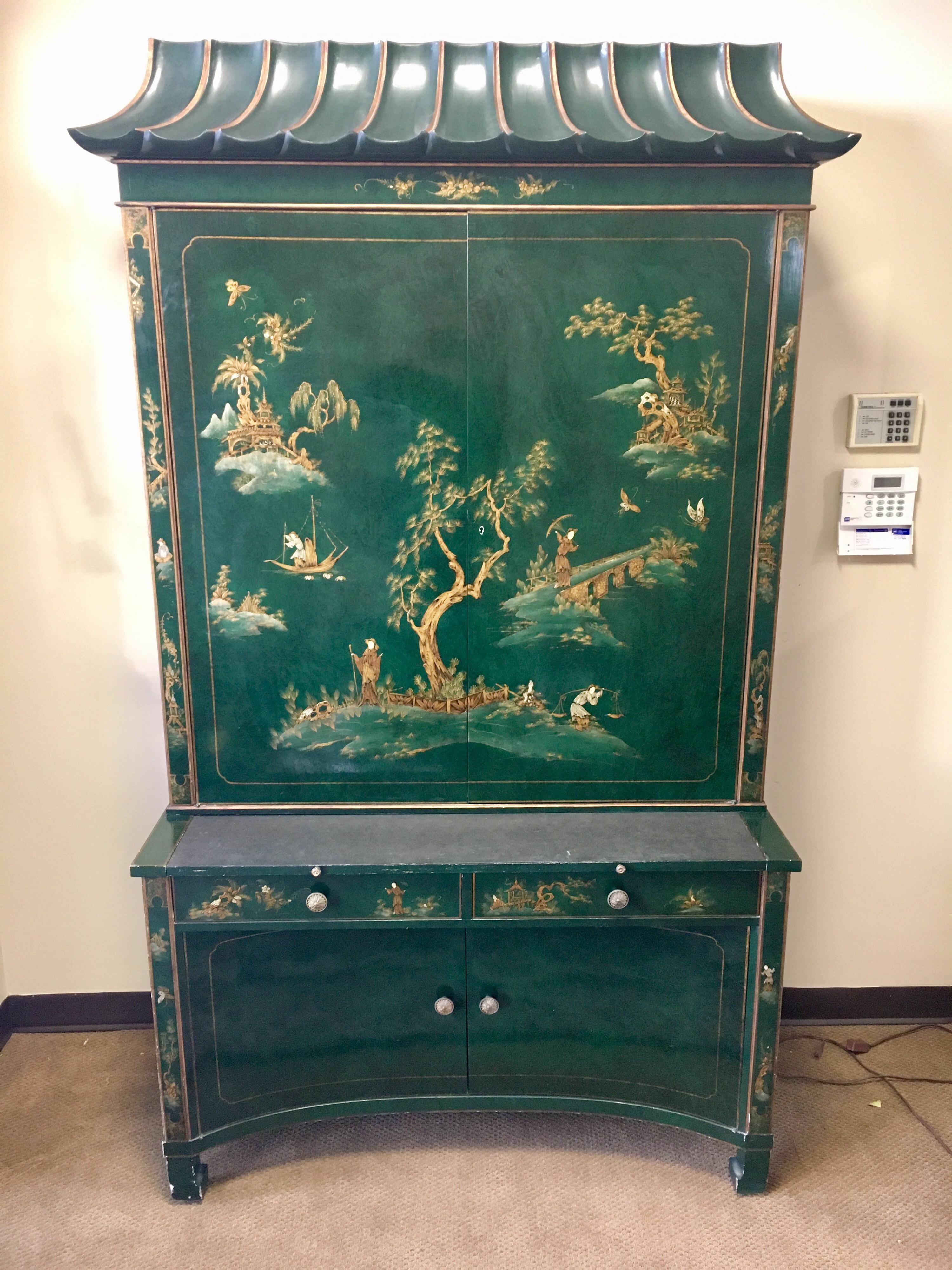 Magnificent emerald green lacquer Chinoiserie secretary two part desk features a pagoda top and hand painted gold figural scenes on an Asian landscape. Top section has two doors that open to glass shelves  and can be illuminated from above when