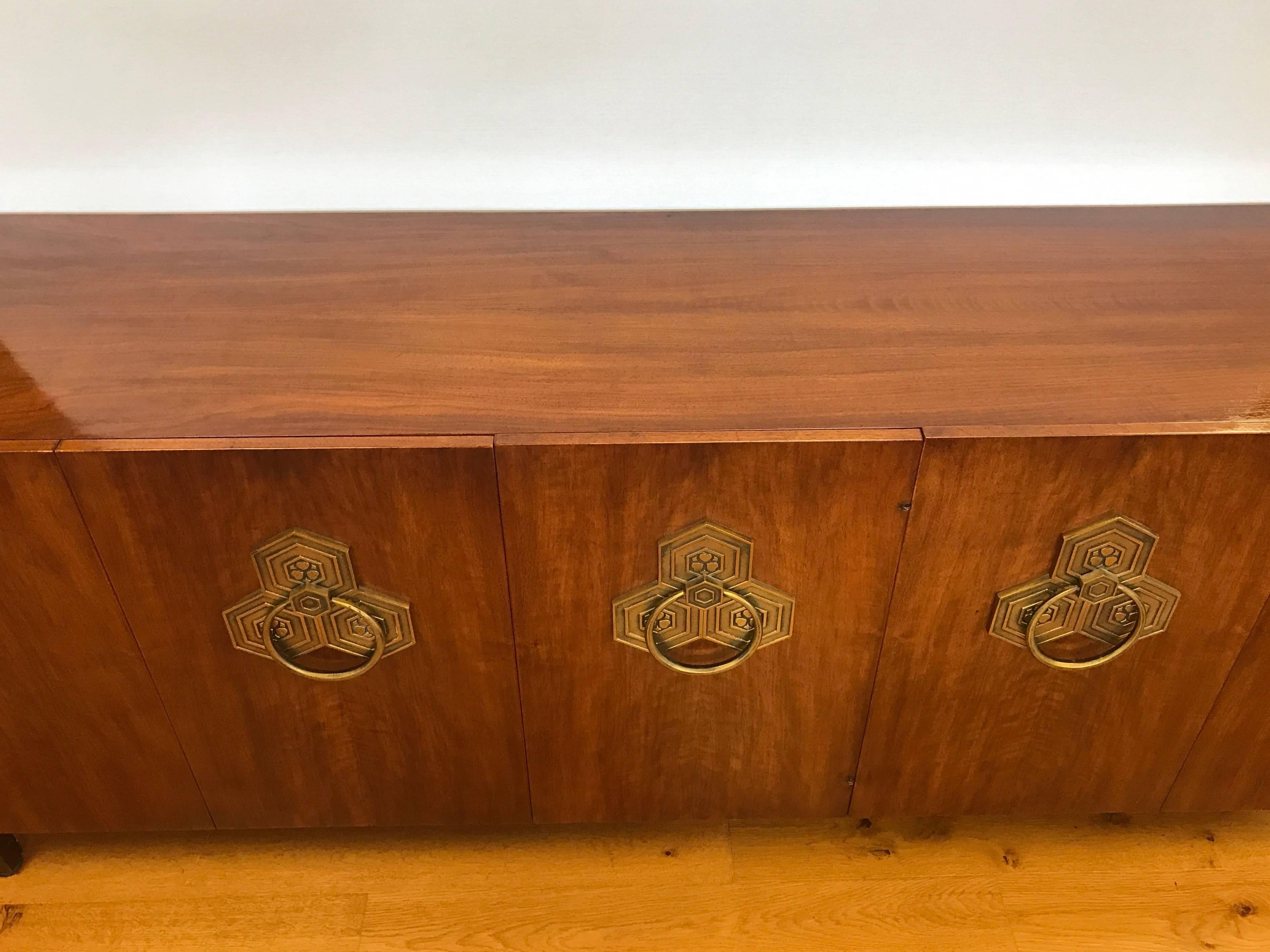 John Widdicomb signed Mid-Century Modern walnut credenza. Accordion doors open to reveal three drawers with silver storage. Middle has two shelves, right side also has two shelves. Original brass hardware. Signed inside drawer. This is an excellent
