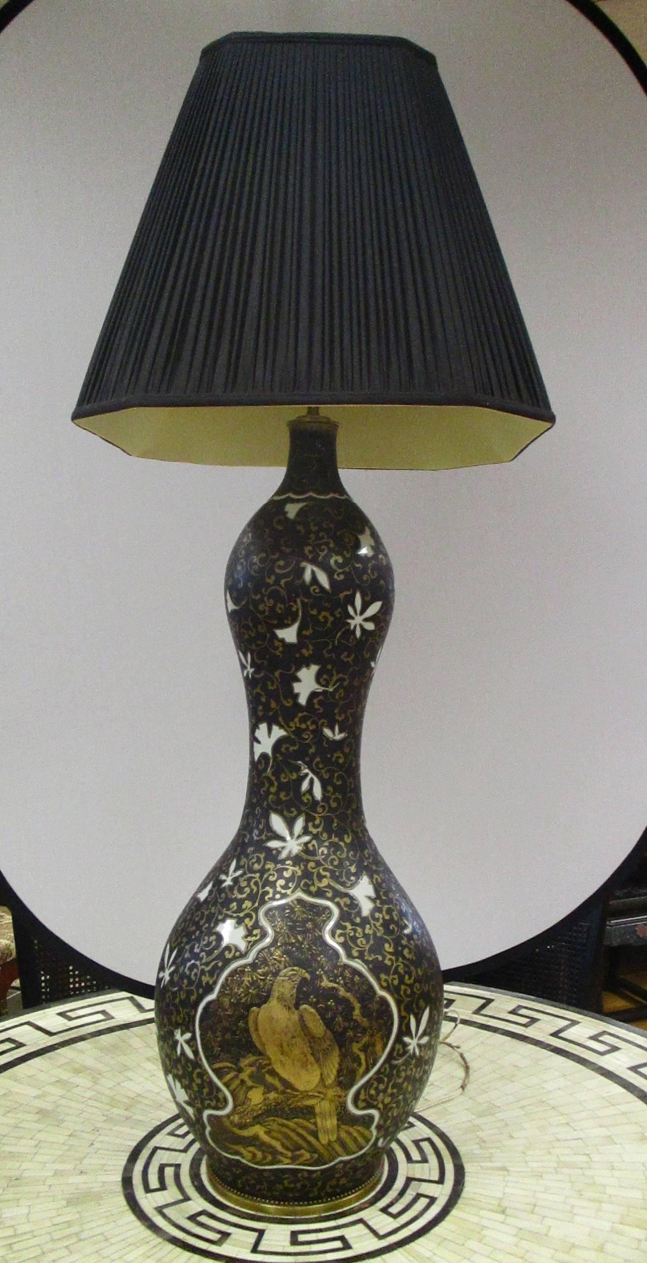 Very tall and heavy Japanese hand-painted black porcelain gourd lamp with white flowers and gold bird with a black pleated shade. Three socket fixture with pull chains. Height from table to socket is 54 inches.
Weight is 80 pounds.