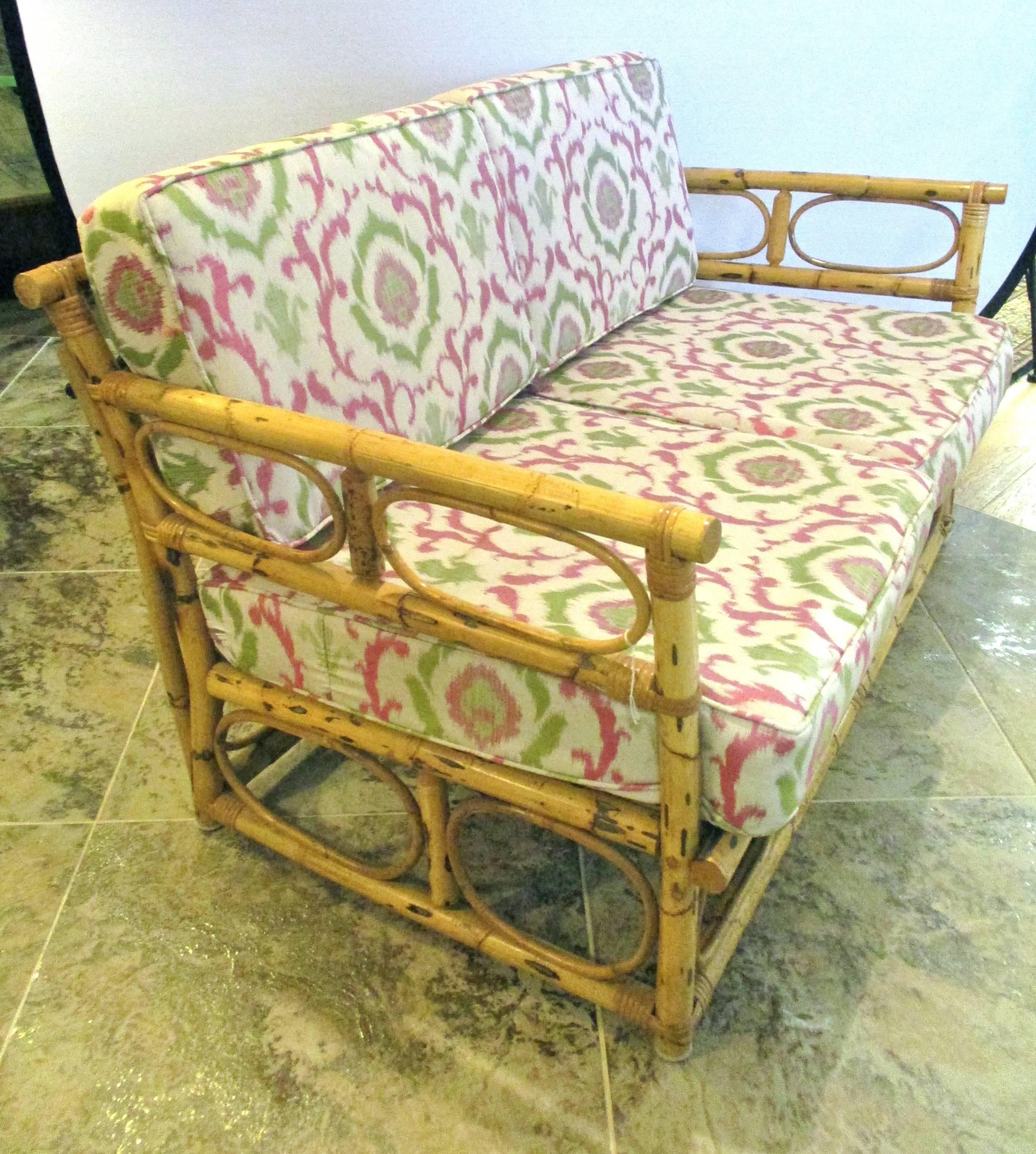 Vintage bamboo settee or settee is crafted of real bamboo and has newly upholstered cushions.