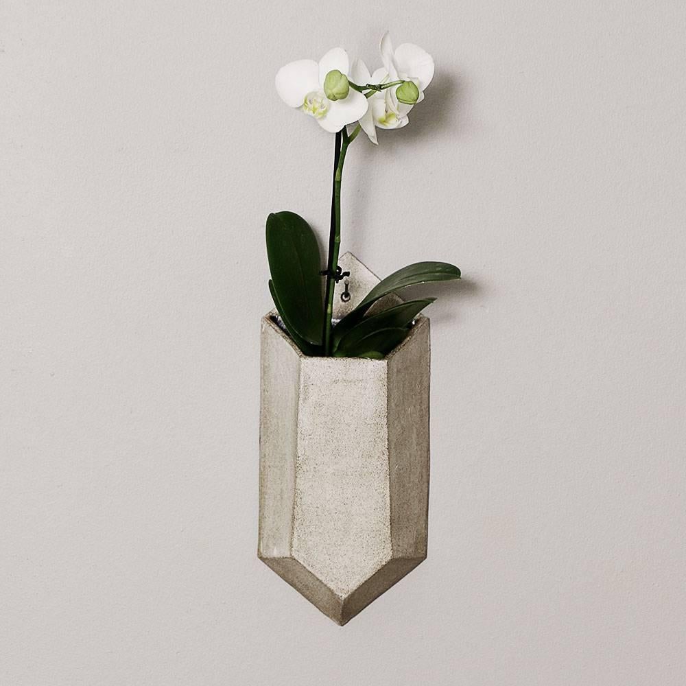 Inspired by Art Deco architecture, the overgrown temples of Angkor, and hidden rooftop gardens of New York City, these handmade pieces are the perfect union of cool geometry and lush greenery. Two faceted forms, the functional wall vessel and the