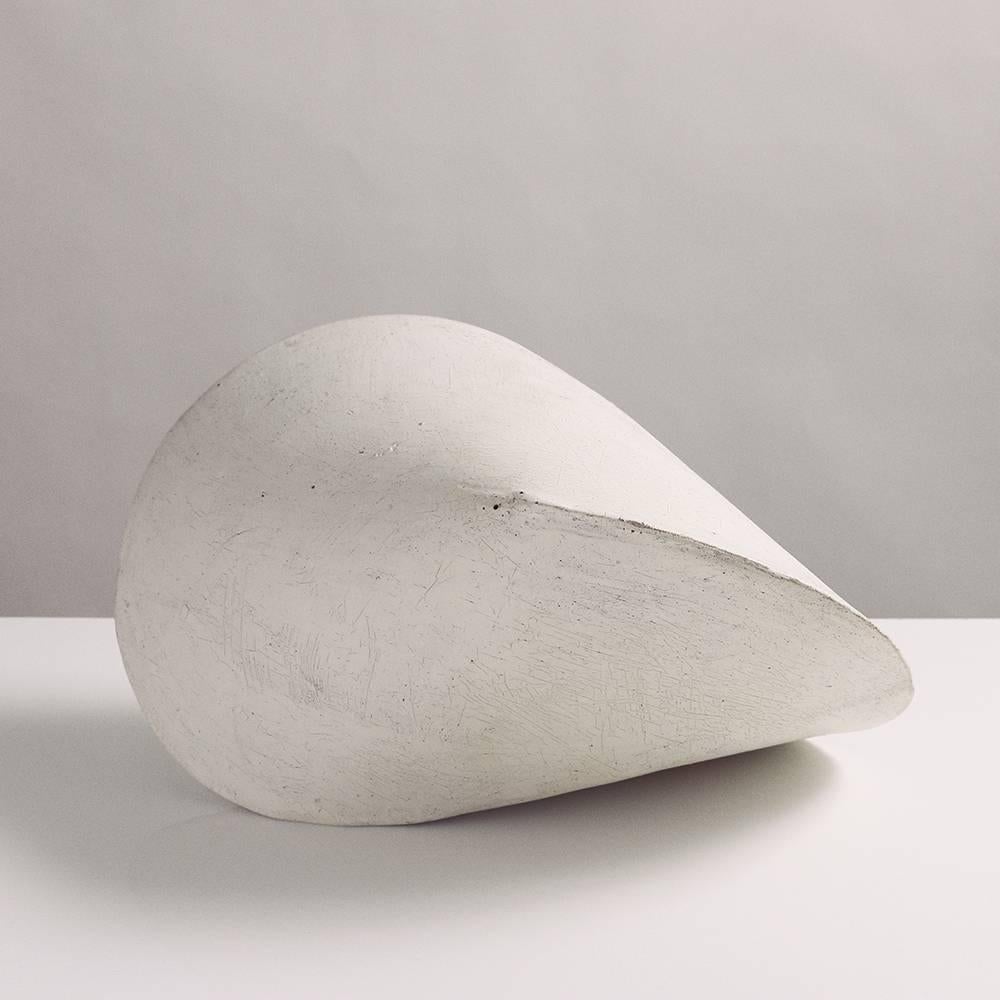 This large stoneware ceramic pod sculpture is both geometric and organic, reminiscent of a perfect seashell. Each pod is hand-built from flat slabs of earthy beige stoneware, then treated with a fine wash of white porcelain, giving it a delicate