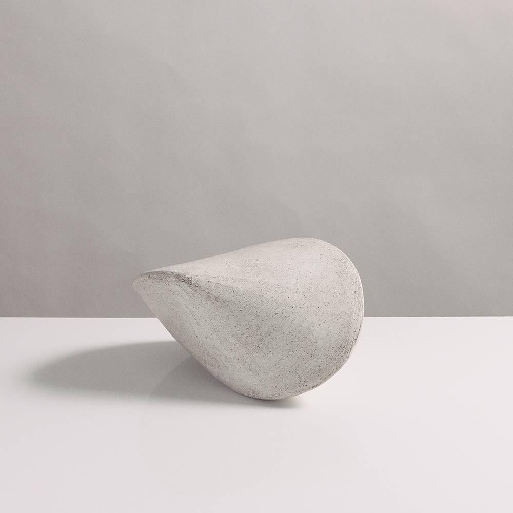 This small stoneware ceramic pod sculpture is both geometric and organic, reminiscent of a perfect seashell. Each pod is hand-built from flat slabs of earthy beige stoneware, then treated with a Fine wash of white porcelain, giving it a delicate