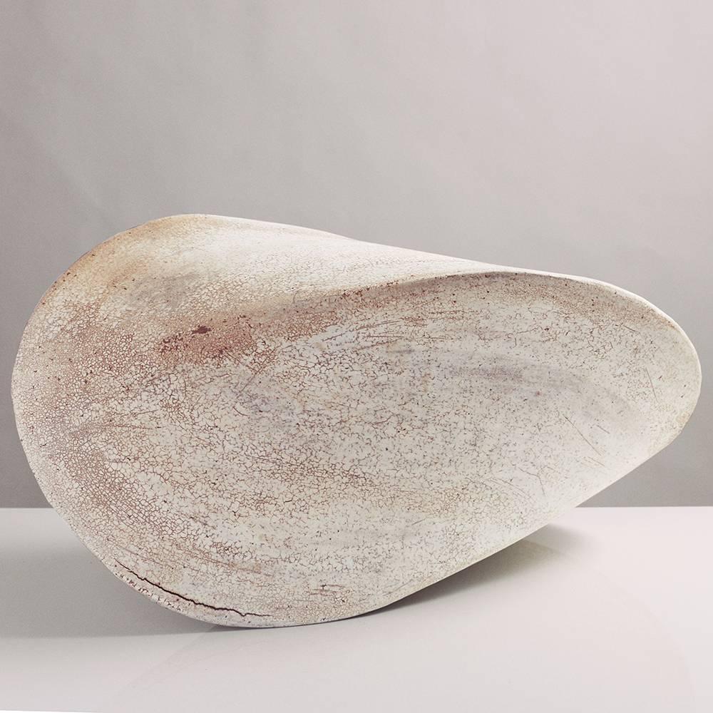 This massive stoneware ceramic pod sculpture is both geometric and organic, reminiscent of a perfect seashell. Each pod is hand-built from flat slabs of earthy beige stoneware, then treated with a fine wash of white porcelain, giving it a delicate