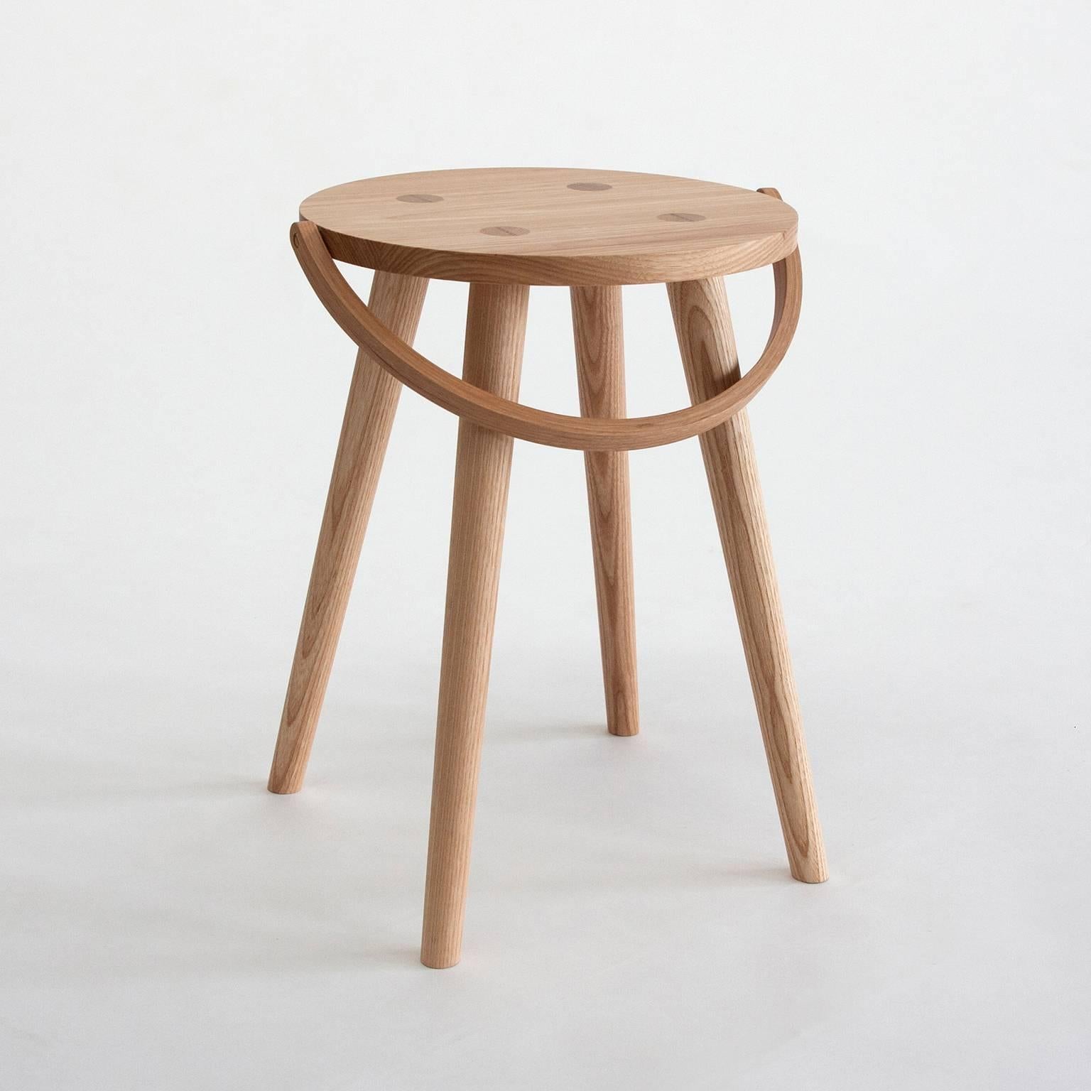 The Single Bucket Stool is a single sized, dining table height seat, or side table. The second of four versions from the Bucket Stool Collection, a family of solid ash furniture featuring bentwood handles. These versatile pieces can function as