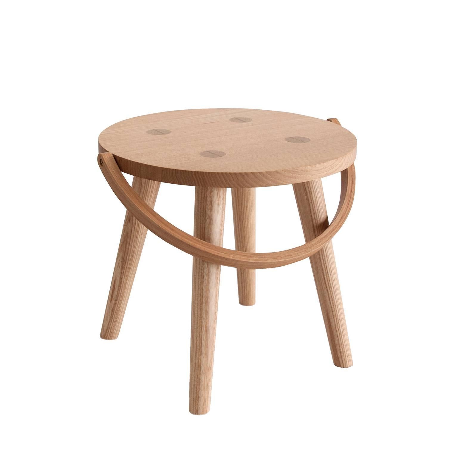 The Step Bucket Stool is a single sized, low seat, or step stool, and the smallest of four versions from the Bucket Stool Collection, a family of solid ash furniture featuring bentwood handles. These versatile pieces can function as either a seat or