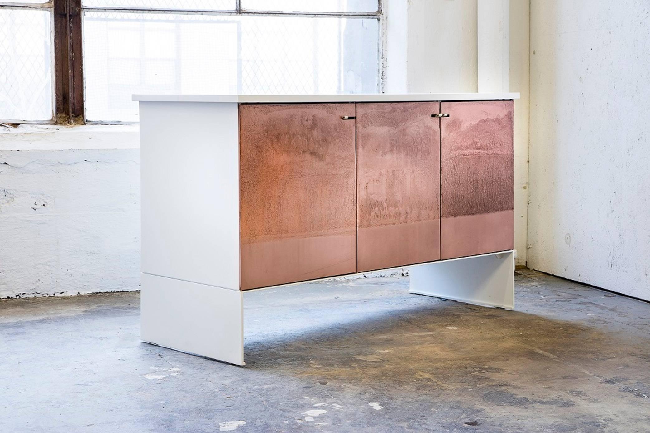 The etch credenza contrasts a rich etched copper texture on the doors with a minimal steel body. The organic texture sets off the clean lines of the frame. The doors swing on custom concealed pivot hinges.